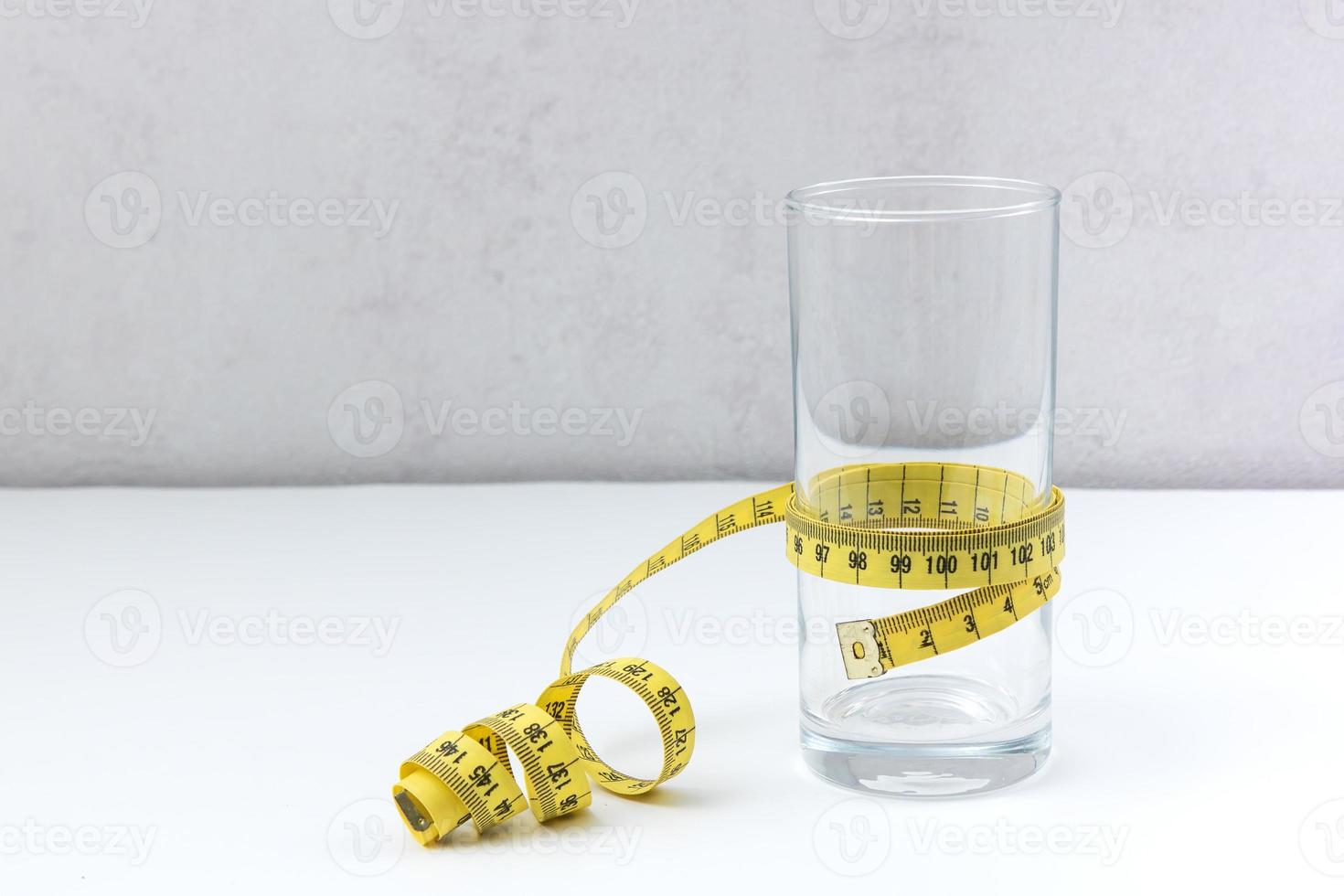 empty glass wrapped with a centimeter tape with copy space, proper nutrition photo
