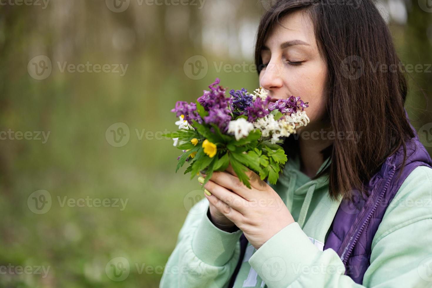 retrato de mujer con primavera ramo de flores de flores en bosque. al aire libre ocio concepto. foto