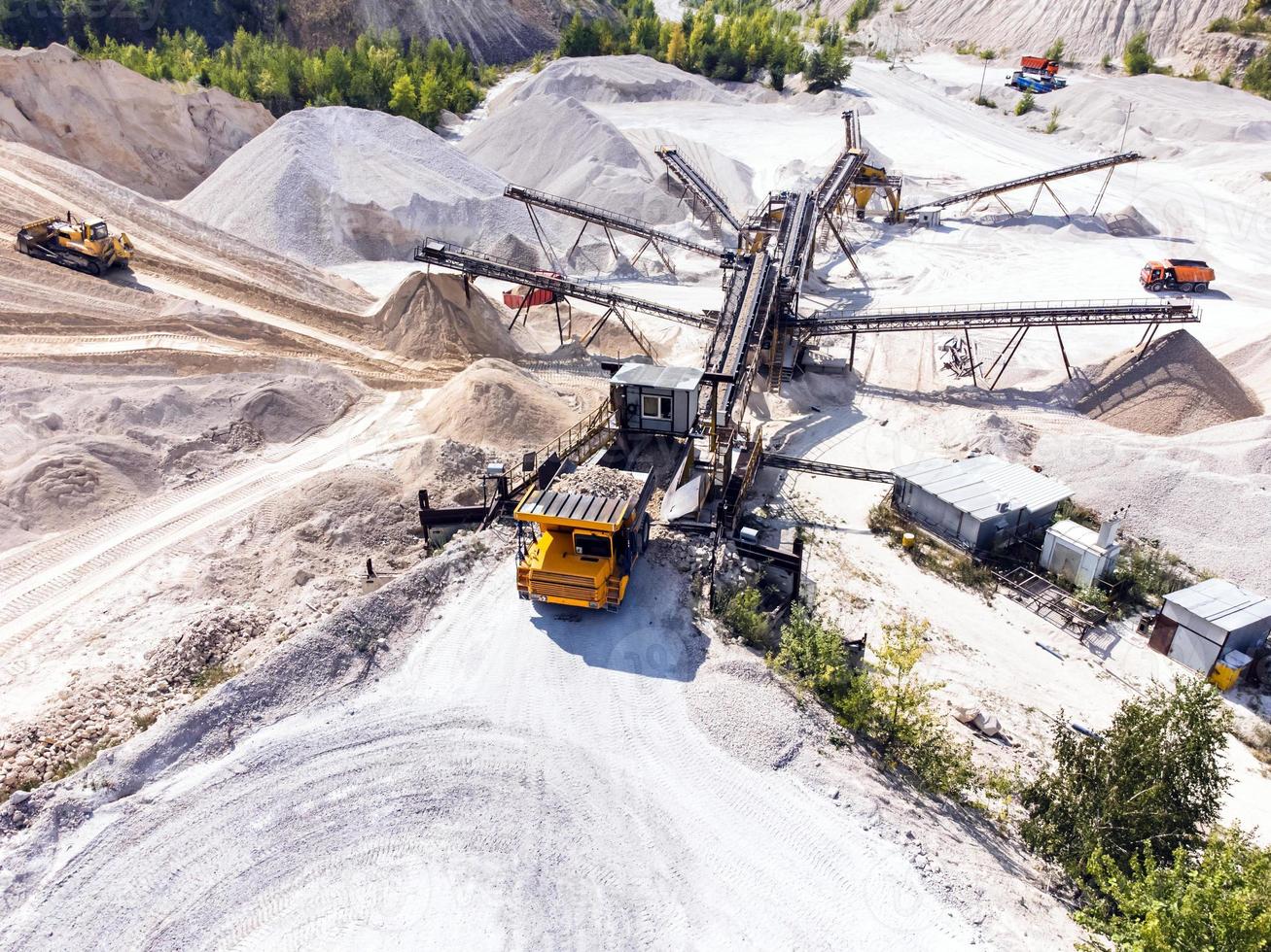 Aerial view of dump truck unloads the gravel onto the conveyor system. photo