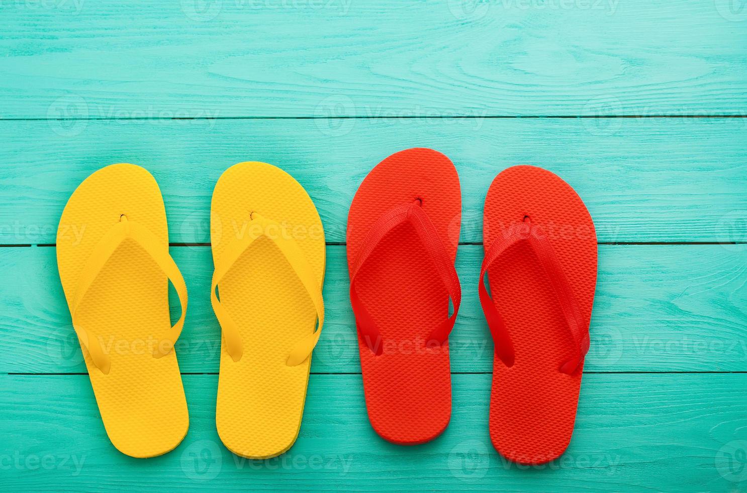 Colorful flip flops on blue wooden background with copy space. Top view photo