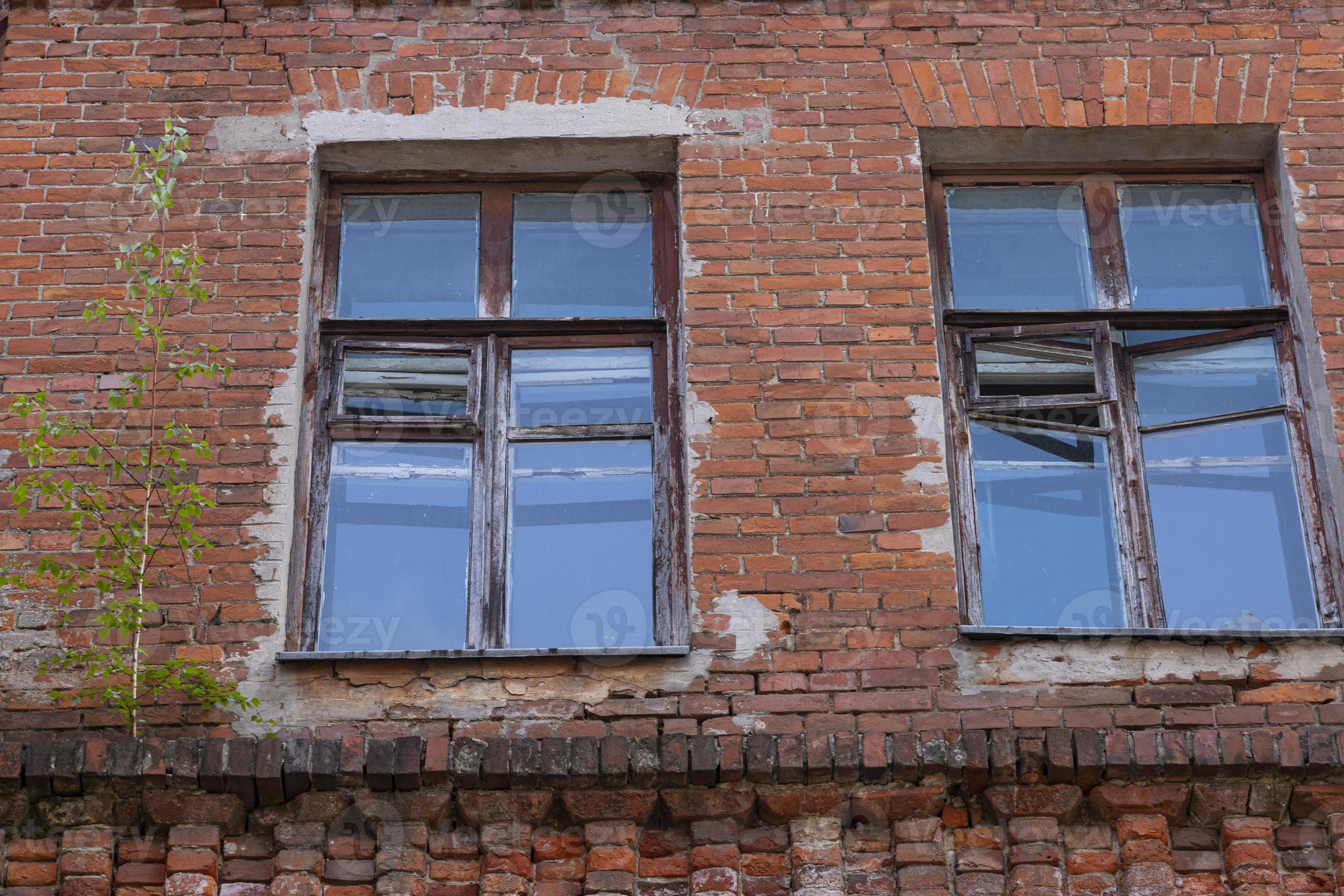 Old windows in a brick house with a reflection of the sky