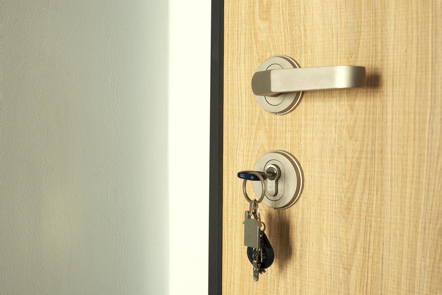 A key with a key fob sticking out in the door lock. Door lock close-up. photo