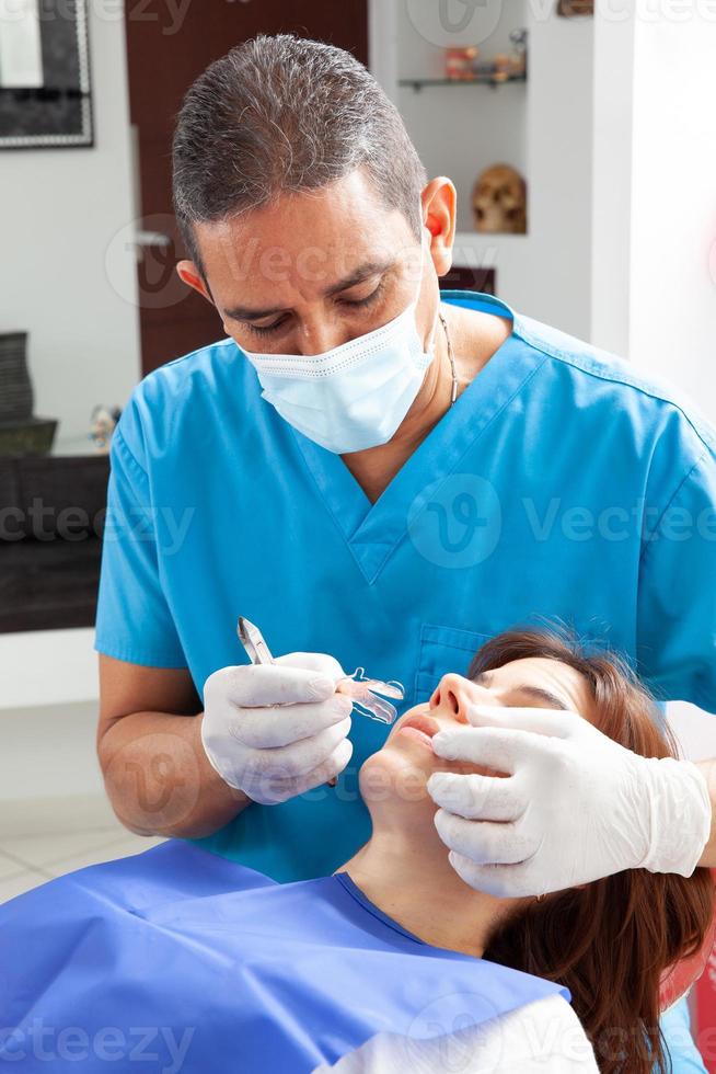 Orthodontic specialist dentist treating an adult female patient photo