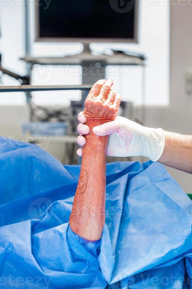 Doctor disinfecting the hand of a patient prior to a hand surgery photo