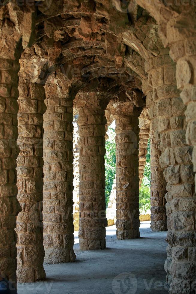 ancient arched gallery perspective, columns and vaults are made of rough, untreated stone photo