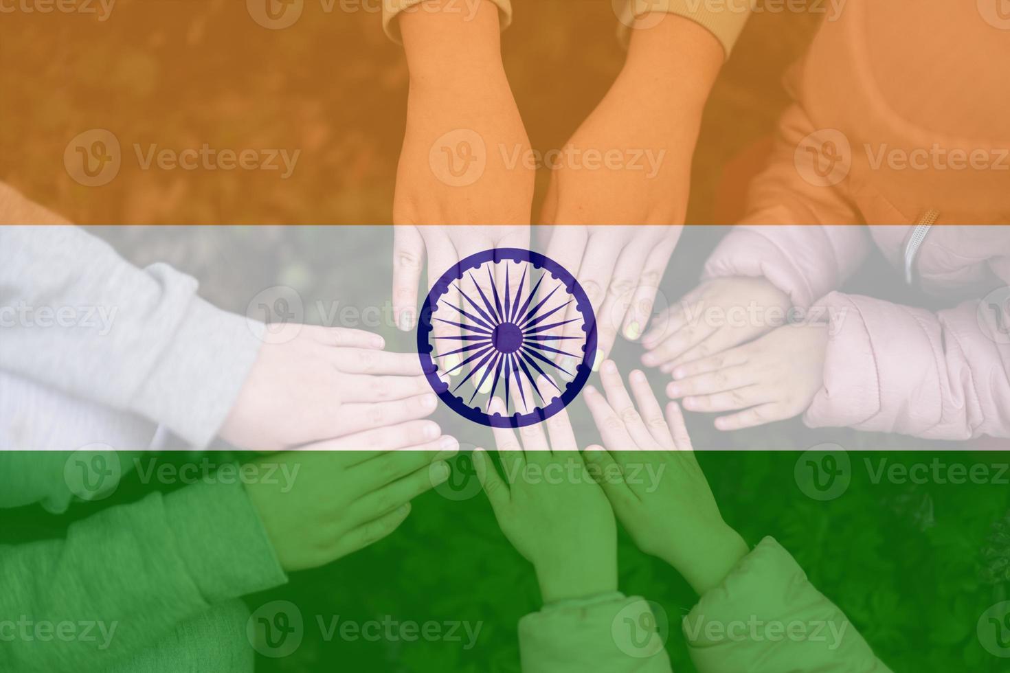 Hands of kids on background of India flag. Indian patriotism and unity concept. photo