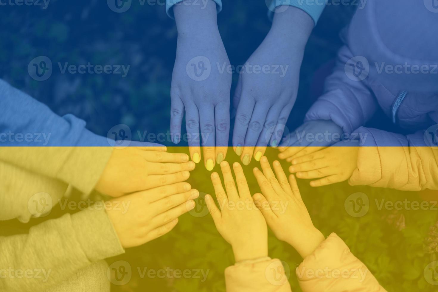 Hands of kids on background of Ukraine flag. Ukrainian patriotism and unity concept. photo