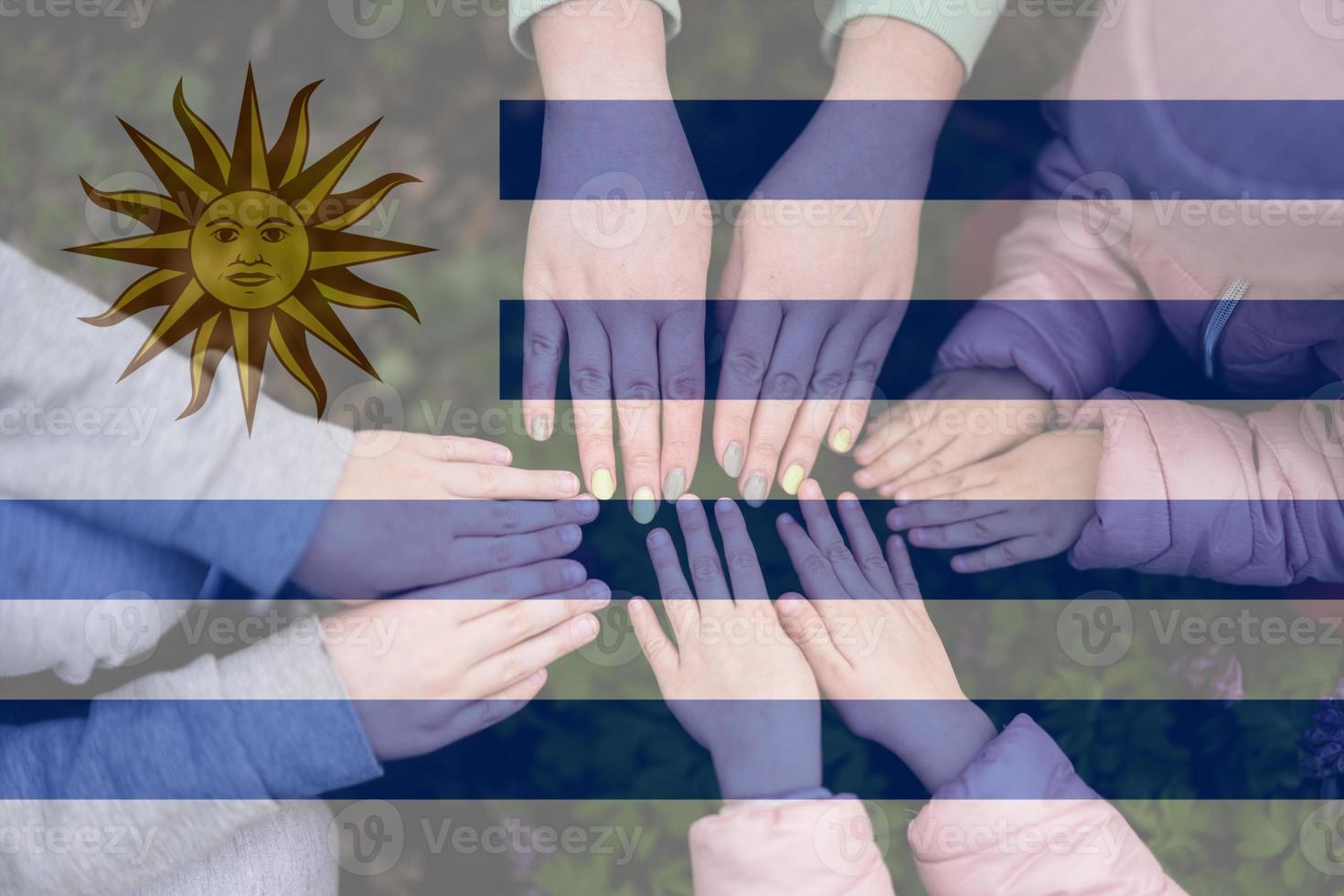 manos de niños en antecedentes de Uruguay bandera. uruguayo patriotismo y unidad concepto. foto