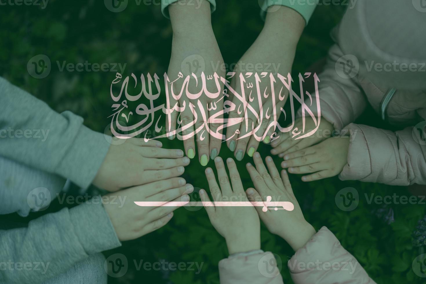 Hands of kids on background of Saudi Arabia flag. Saudi Arabian patriotism and unity concept. photo