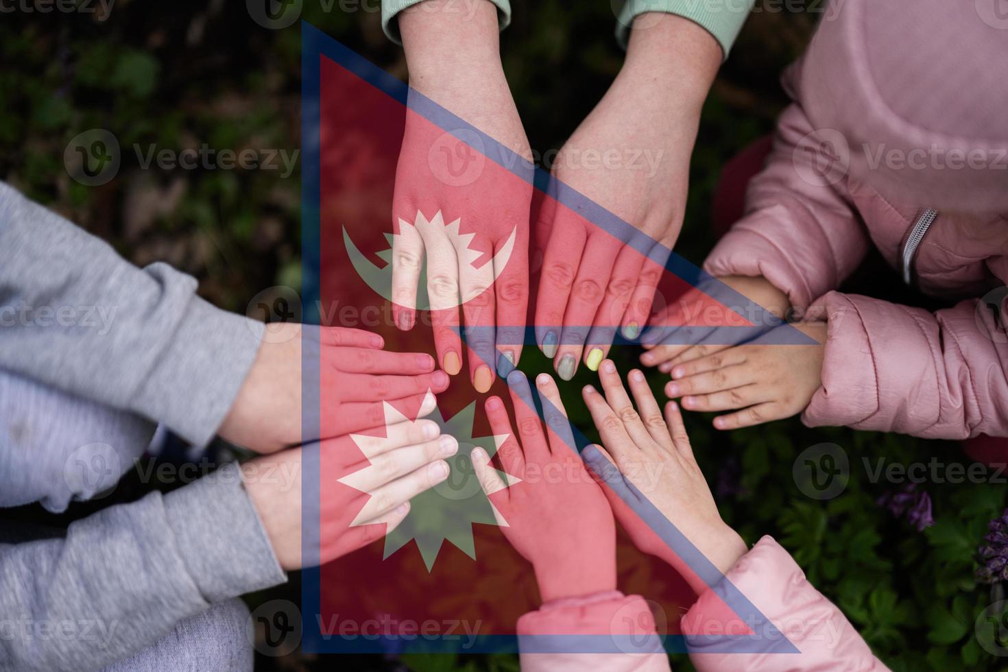 Hands of kids on background of Nepal flag. Nepali patriotism and unity concept. photo