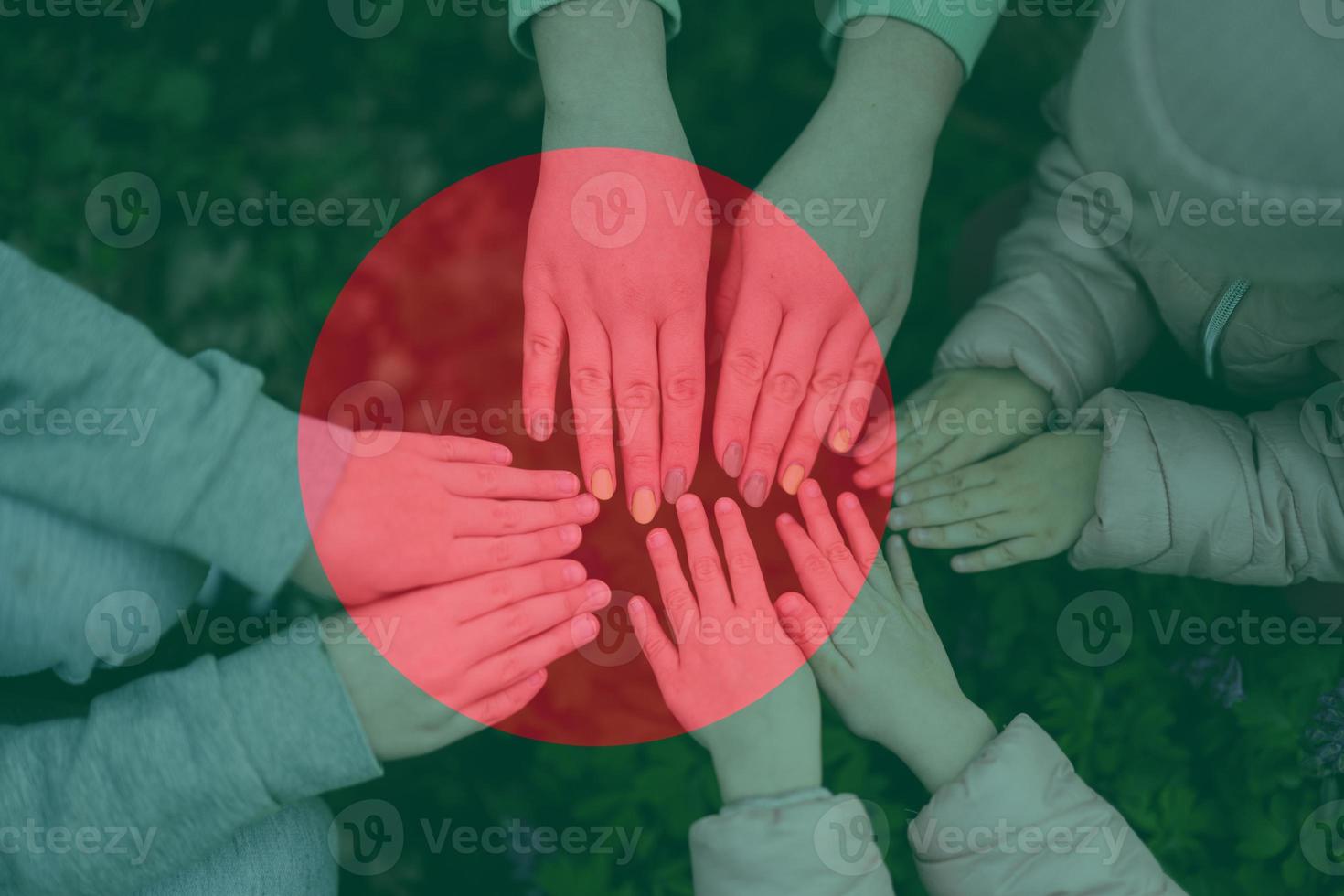 Hands of kids on background of Bangladesh flag. Bangladeshi patriotism and unity concept. photo