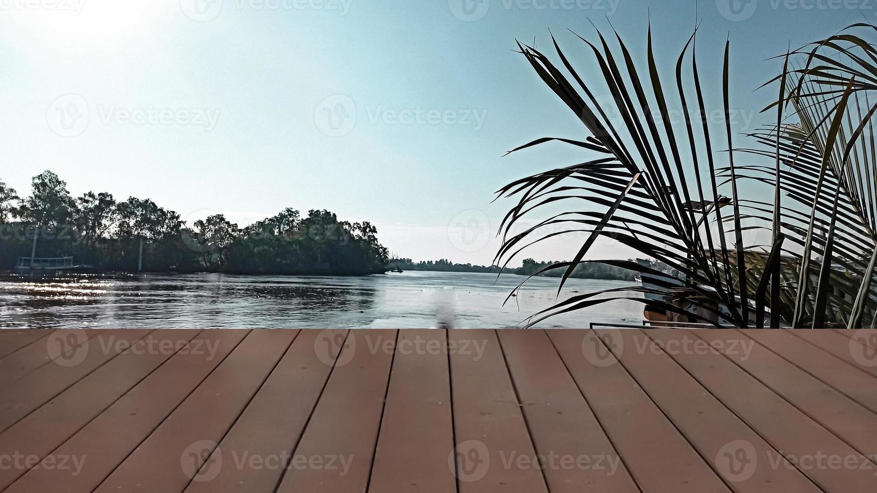 empty Wooden table top on the background of the river and palm leaves. focus nature green, abstract nature background with green leves. photo