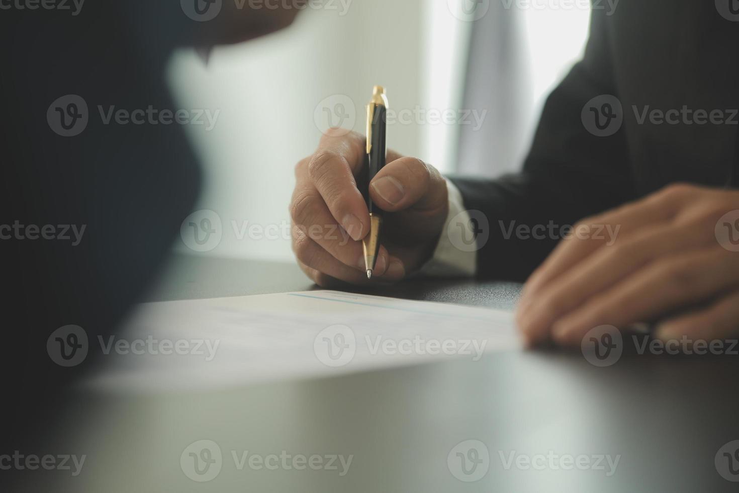 concepto de justicia y derecho. El asesor legal presenta al cliente un contrato firmado con mazo y derecho legal o una reunión de equipo legal en el bufete de abogados en segundo plano. foto