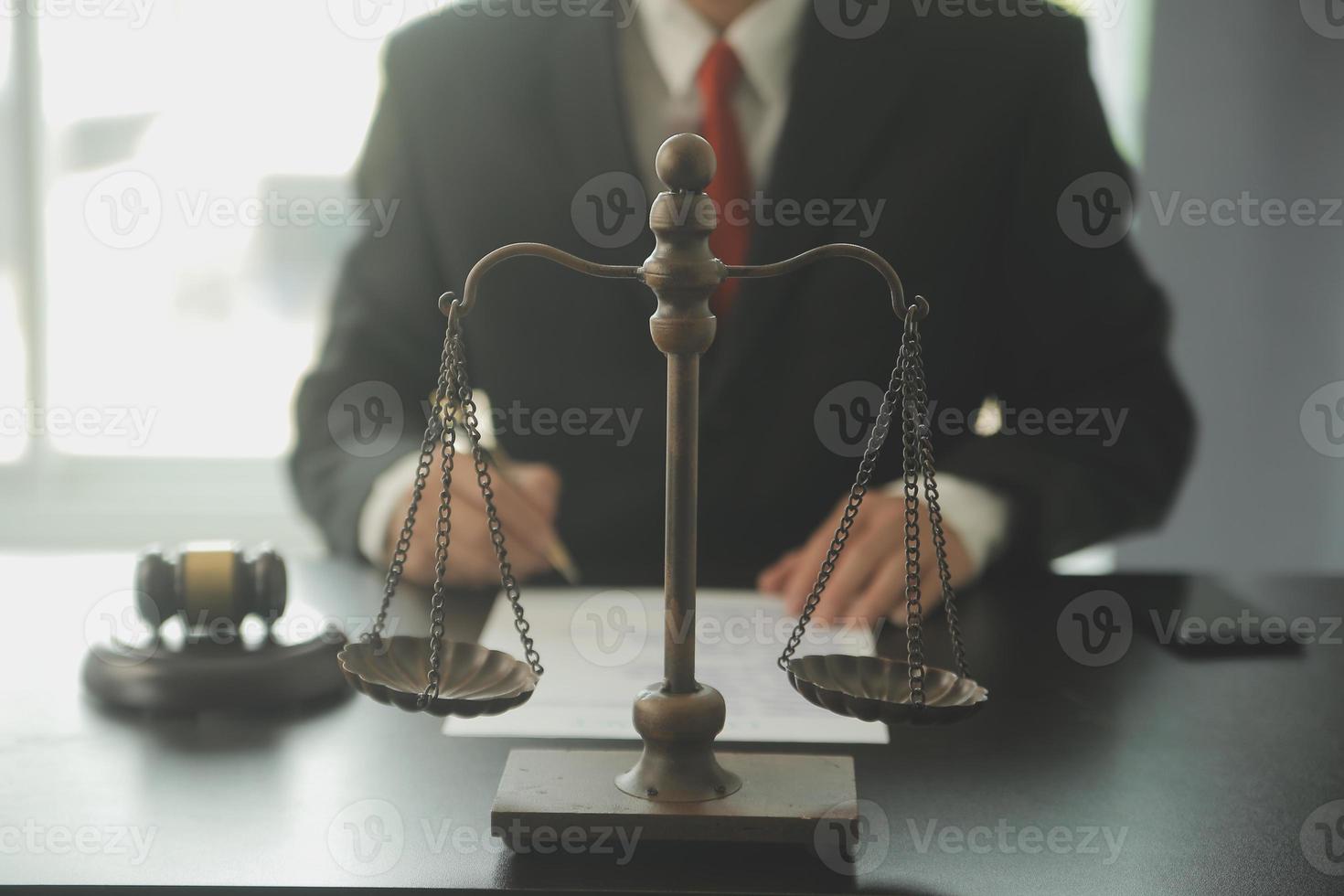 Justice and Law concept. Legal counsel presents to the client a signed contract with gavel and legal law or legal having team meeting at law firm in background photo