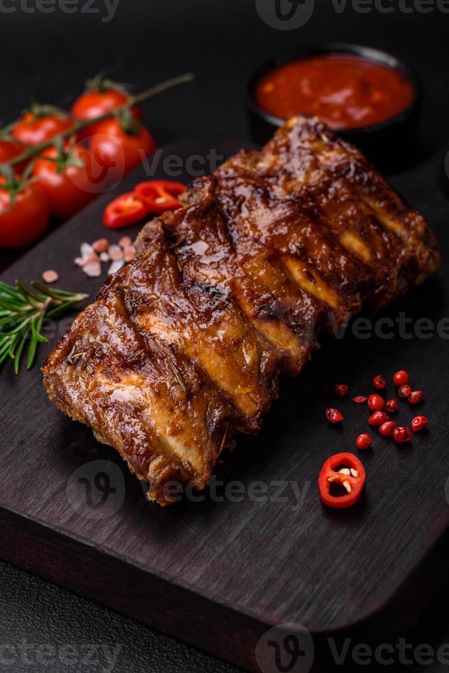 delicioso A la parrilla Cerdo costillas con salsa, especias y hierbas foto