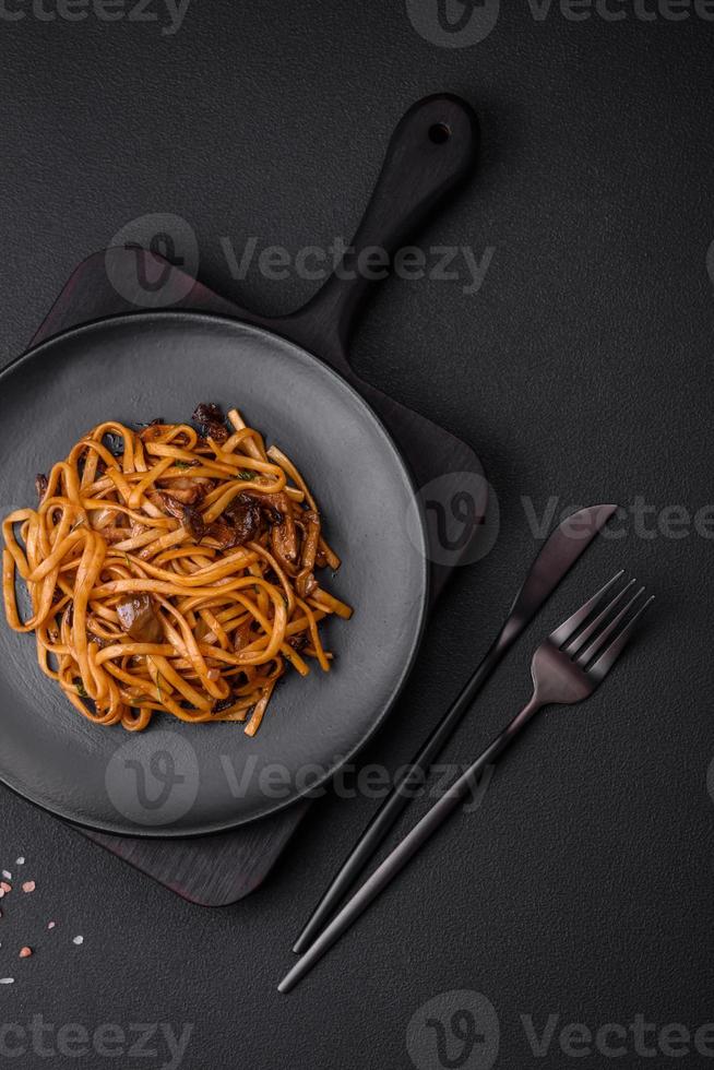 delicioso tallarines o udon con hongos, sal, especias y hierbas foto