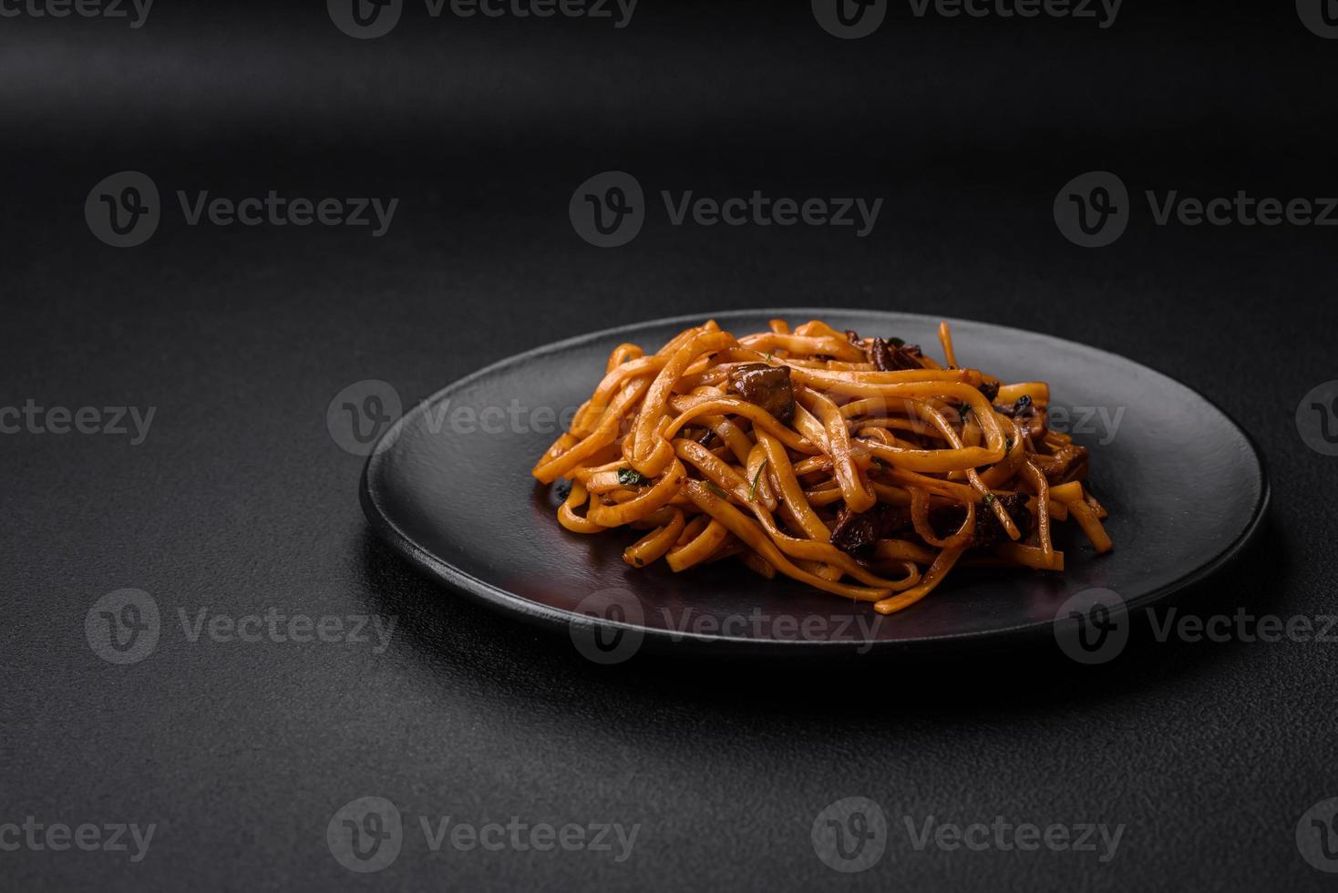 delicioso tallarines o udon con hongos, sal, especias y hierbas foto