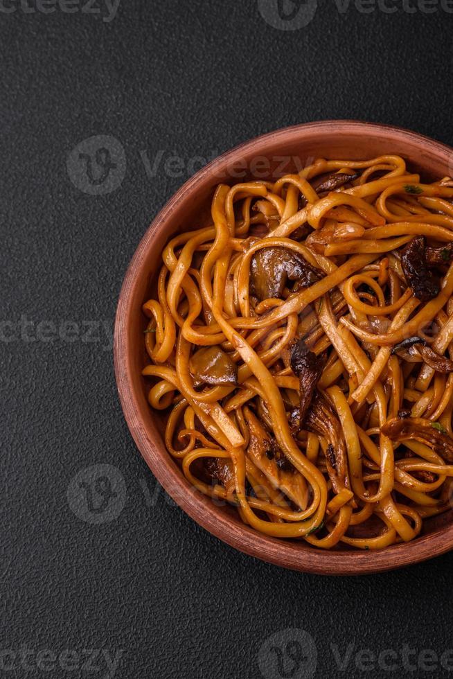 delicioso tallarines o udon con hongos, sal, especias y hierbas foto