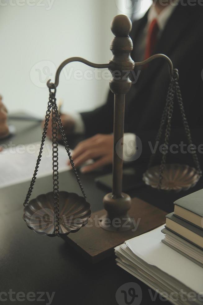 Justice and Law concept. Legal counsel presents to the client a signed contract with gavel and legal law or legal having team meeting at law firm in background photo