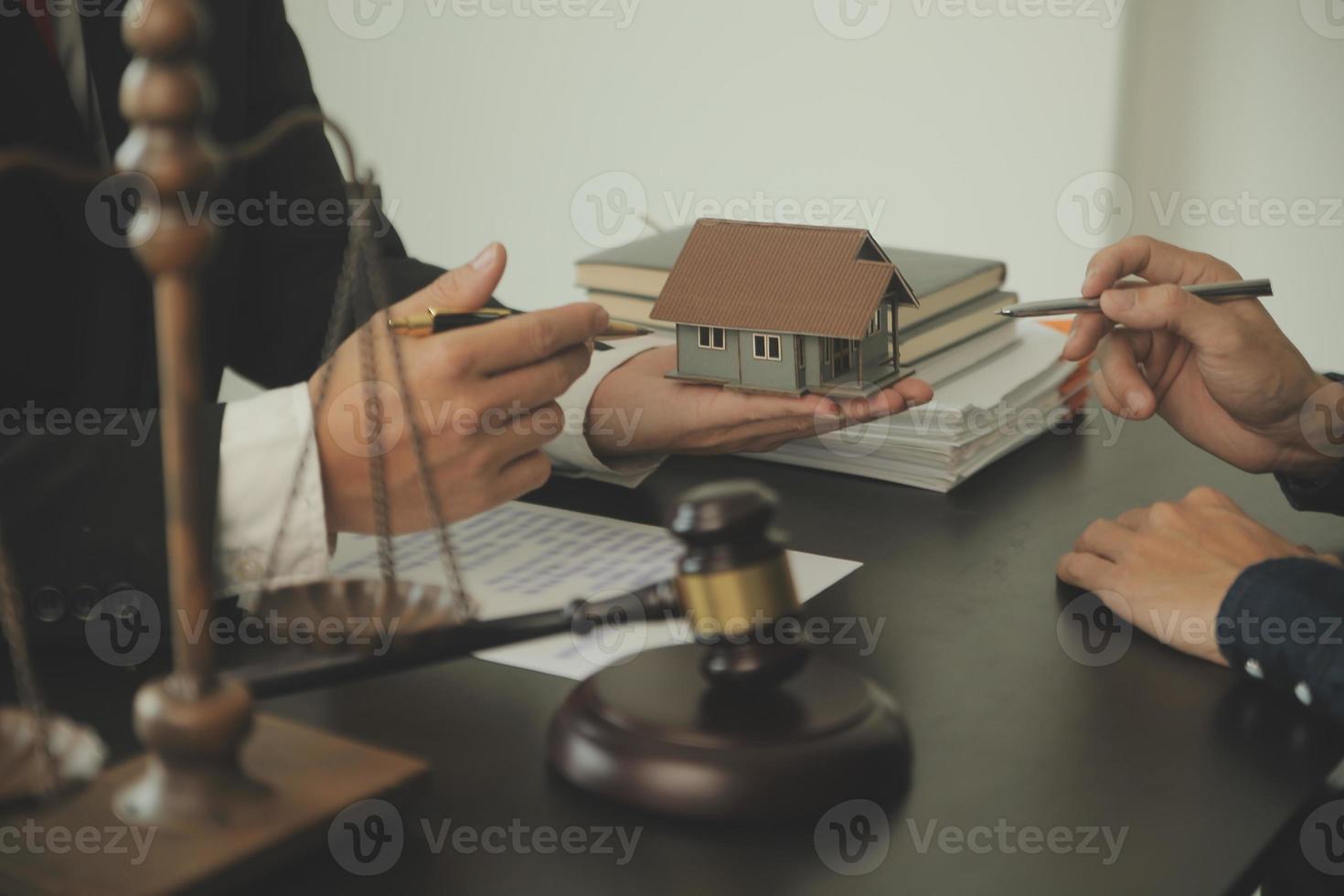 Justice and Law concept. Legal counsel presents to the client a signed contract with gavel and legal law or legal having team meeting at law firm in background photo