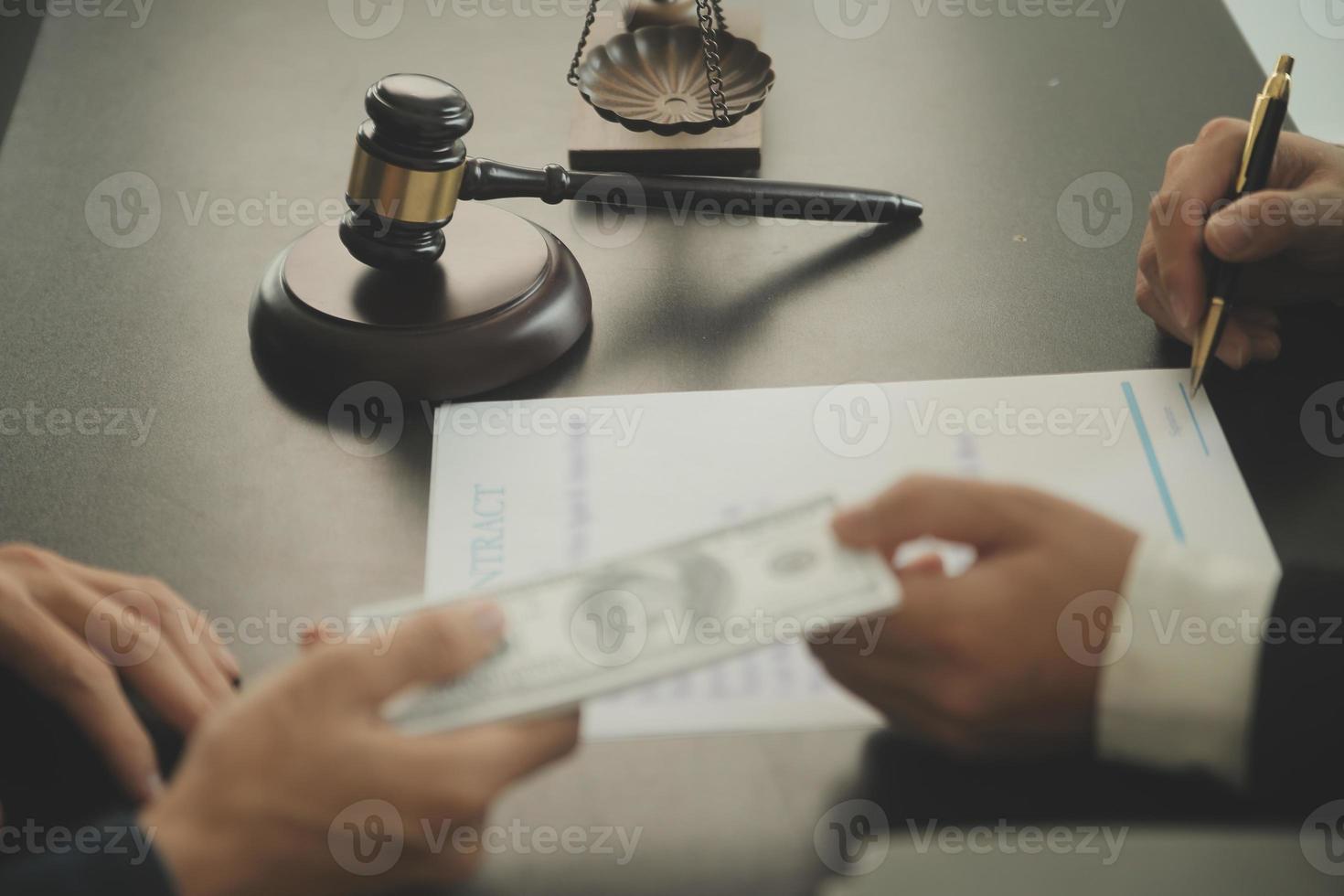 Justice and Law concept. Legal counsel presents to the client a signed contract with gavel and legal law or legal having team meeting at law firm in background photo