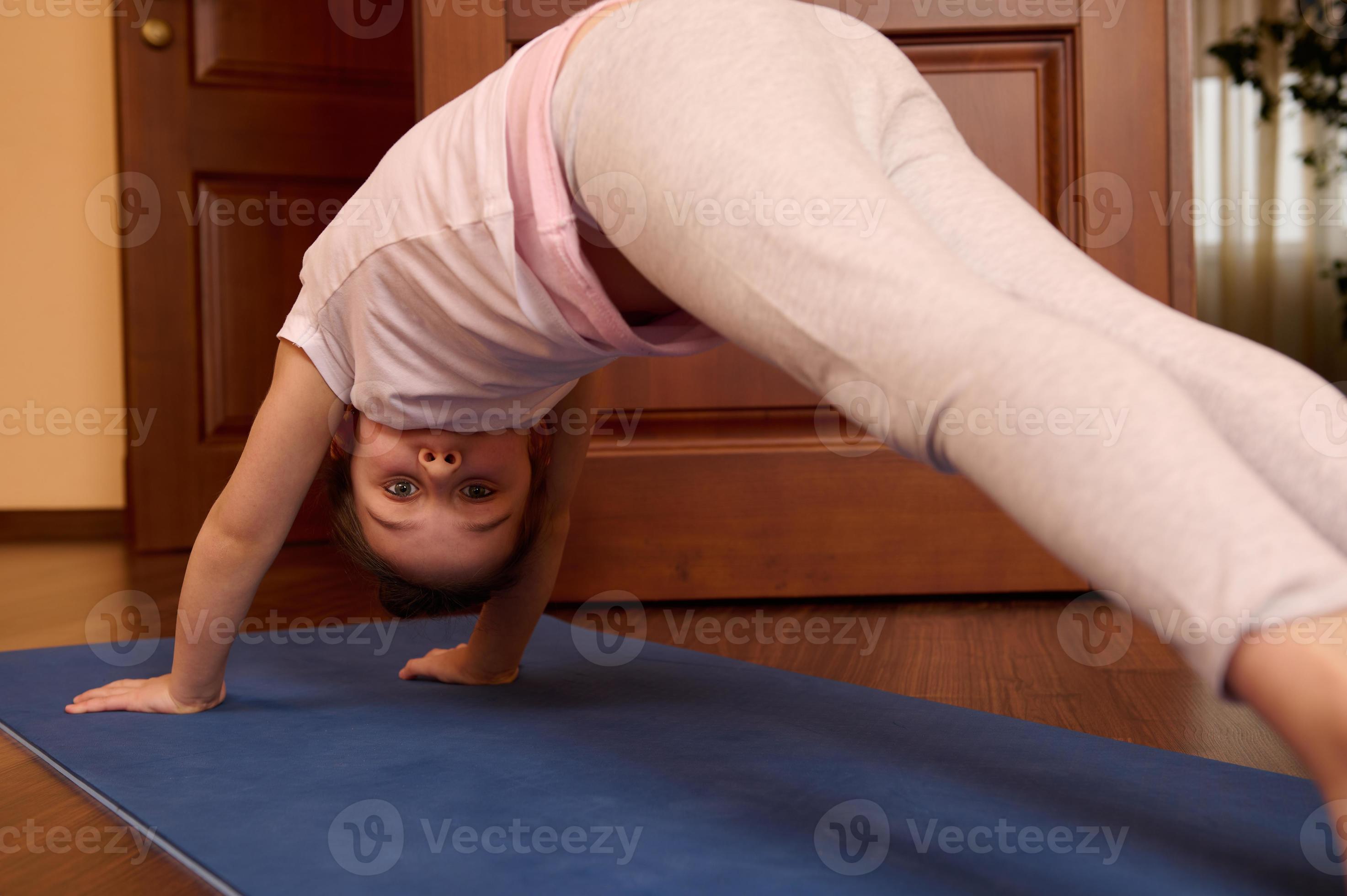 Portrait of 5-6 years old little child girl in downward facing dog