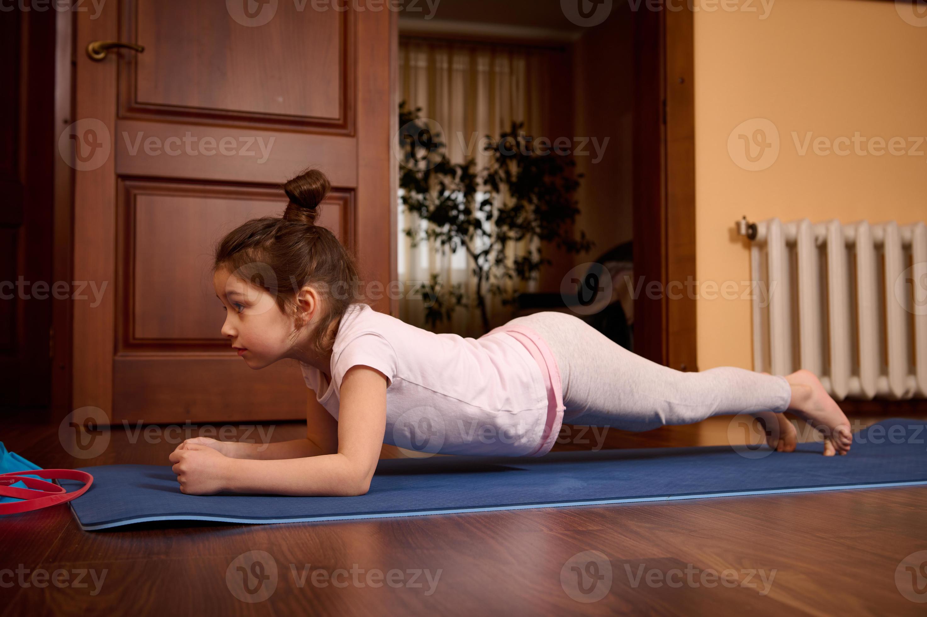 Little girl practicing yoga, doing push ups, press ups, four limbed staff  exercise, chaturanga dandasana pose indoors 22971365 Stock Photo at Vecteezy