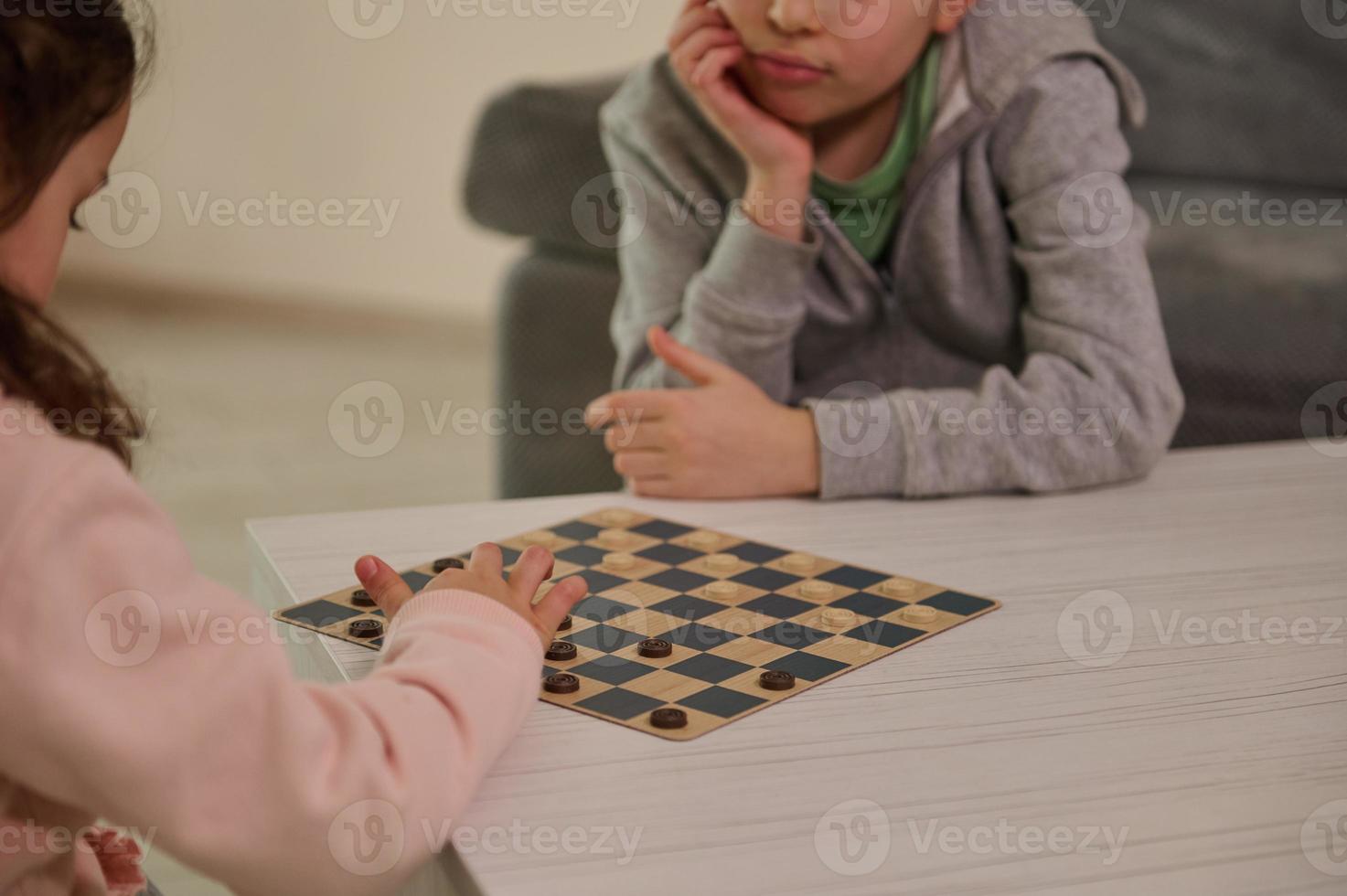 Handsome school aged kids playing checkers table game, staying at home Quarantine concept. Board game and kids leisure concept. Family time. photo