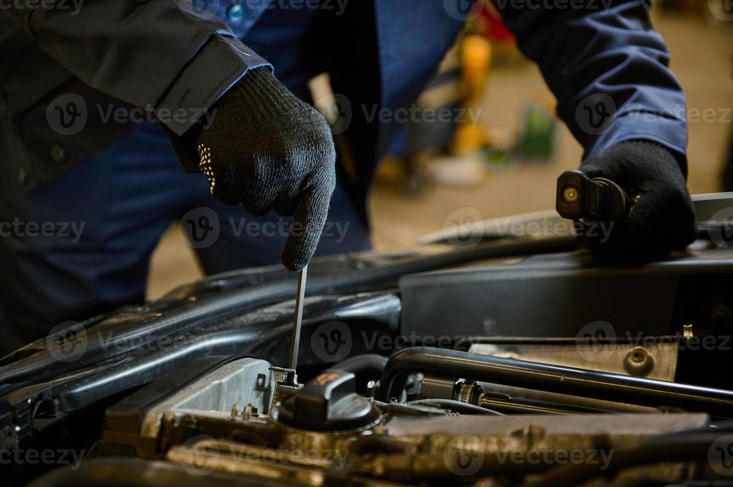 Close-up auto mechanic hands with wrench repairing car in the garage of a repair shop photo