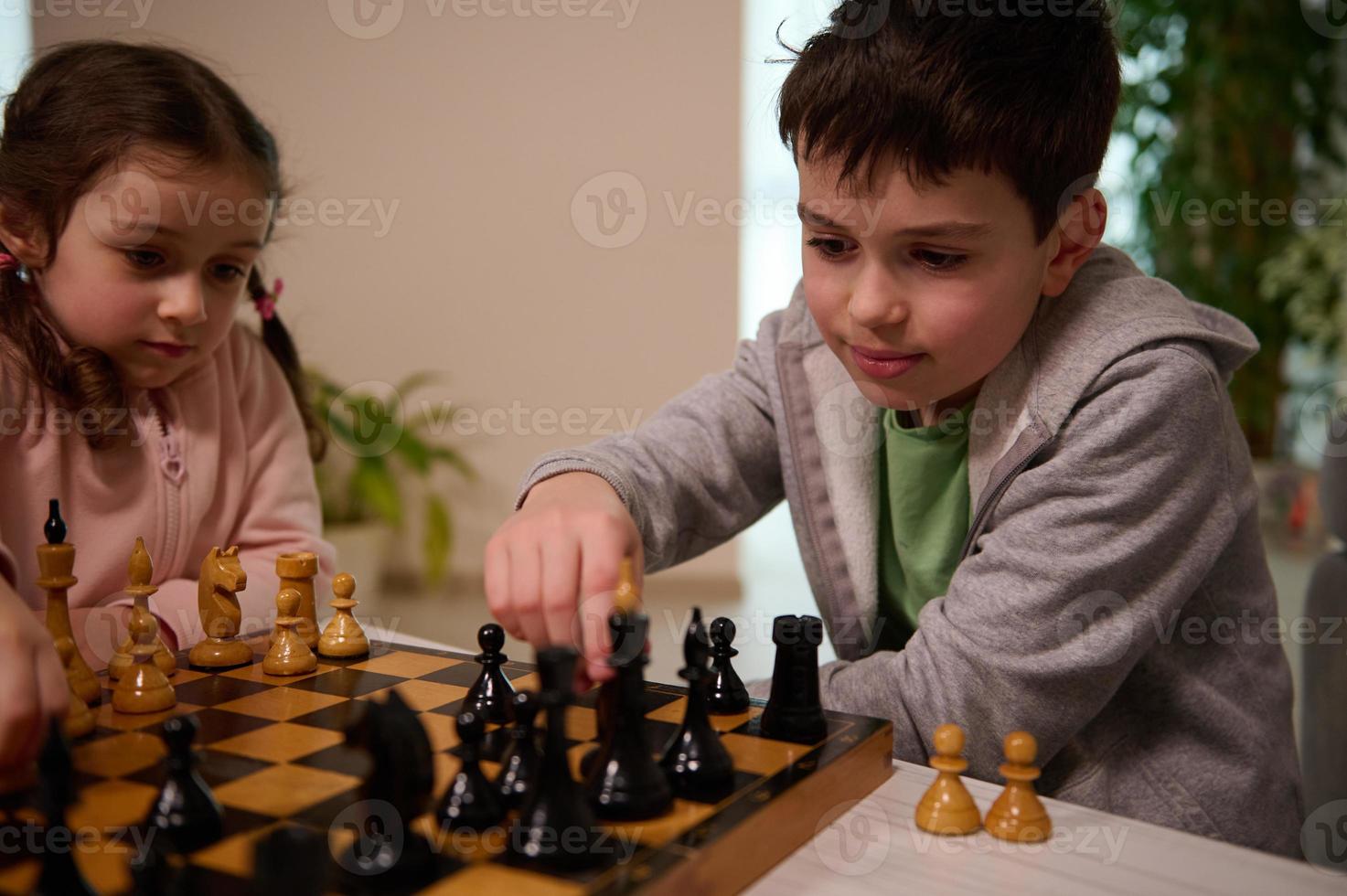 un ajedrez juego para un inteligente mente. hermosa inteligente niños jugando ajedrez juntos en hogar interior. el concepto de intelectual tablero juegos y lógica desarrollo para niños foto