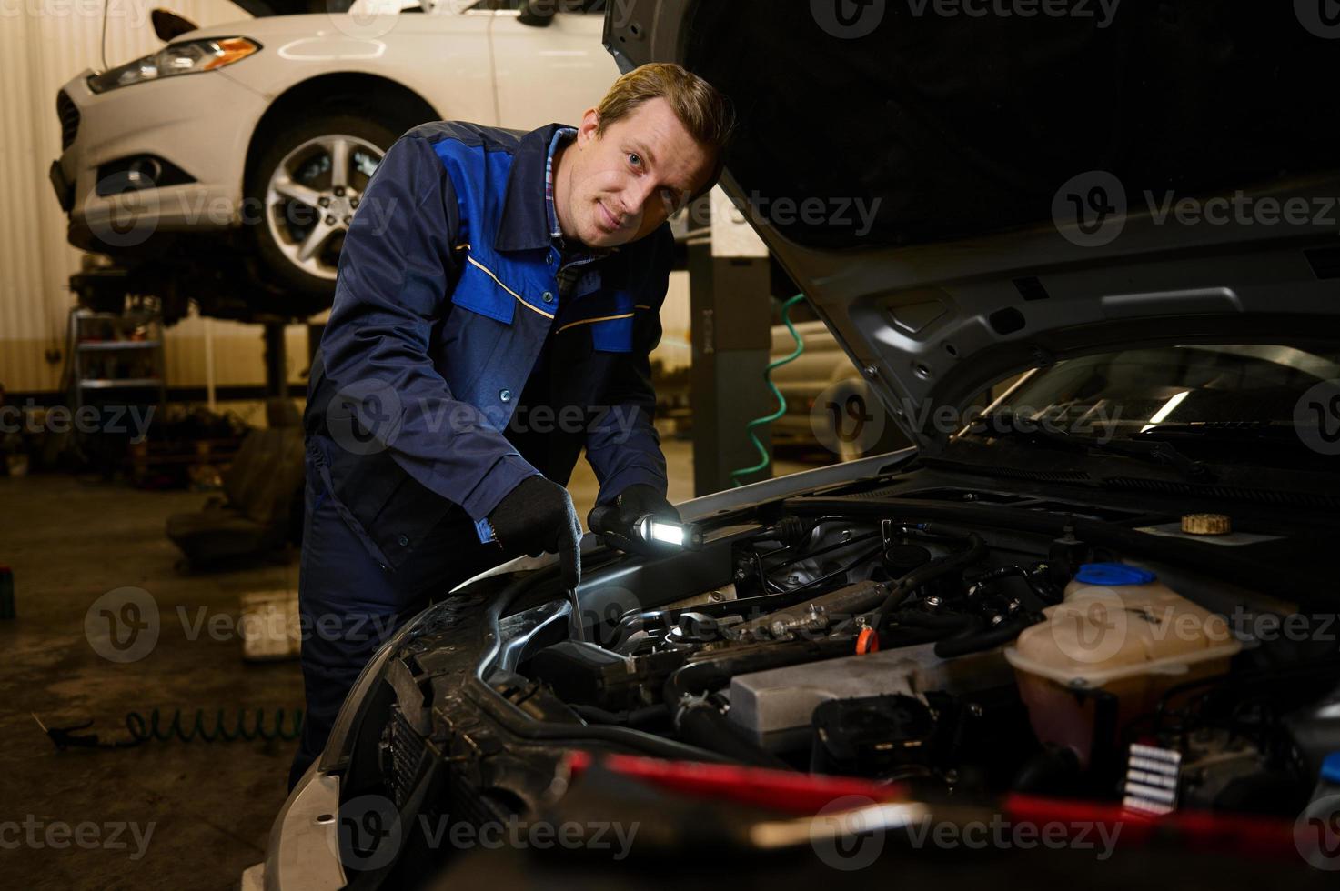 Technician automotive checking car in the garage. Auto mechanic working with engine in garage, car service technician repairing customer care at automobile service center. photo