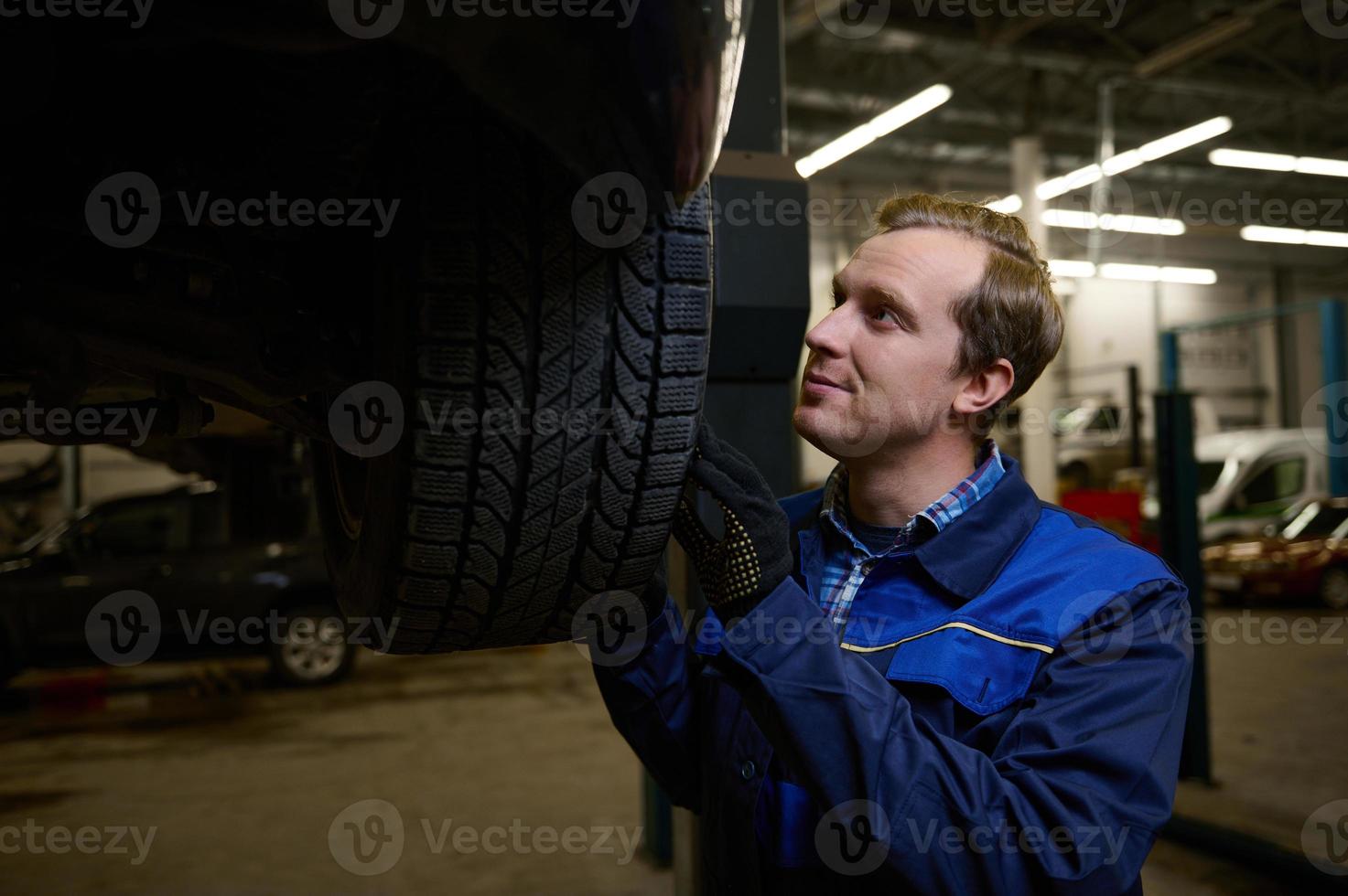 Mechanic checking tire in maintenance service center. Technician or engineer professional work for customer, car repair concept photo