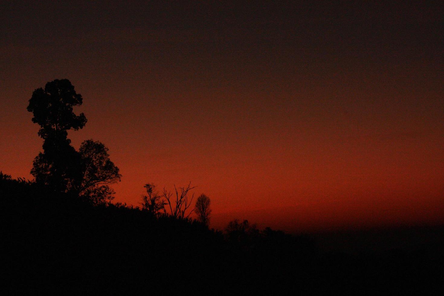 hermosa silueta de momentos en natural amanecer y puesta de sol en el montaña. paz, soledad y haloween concepto. foto