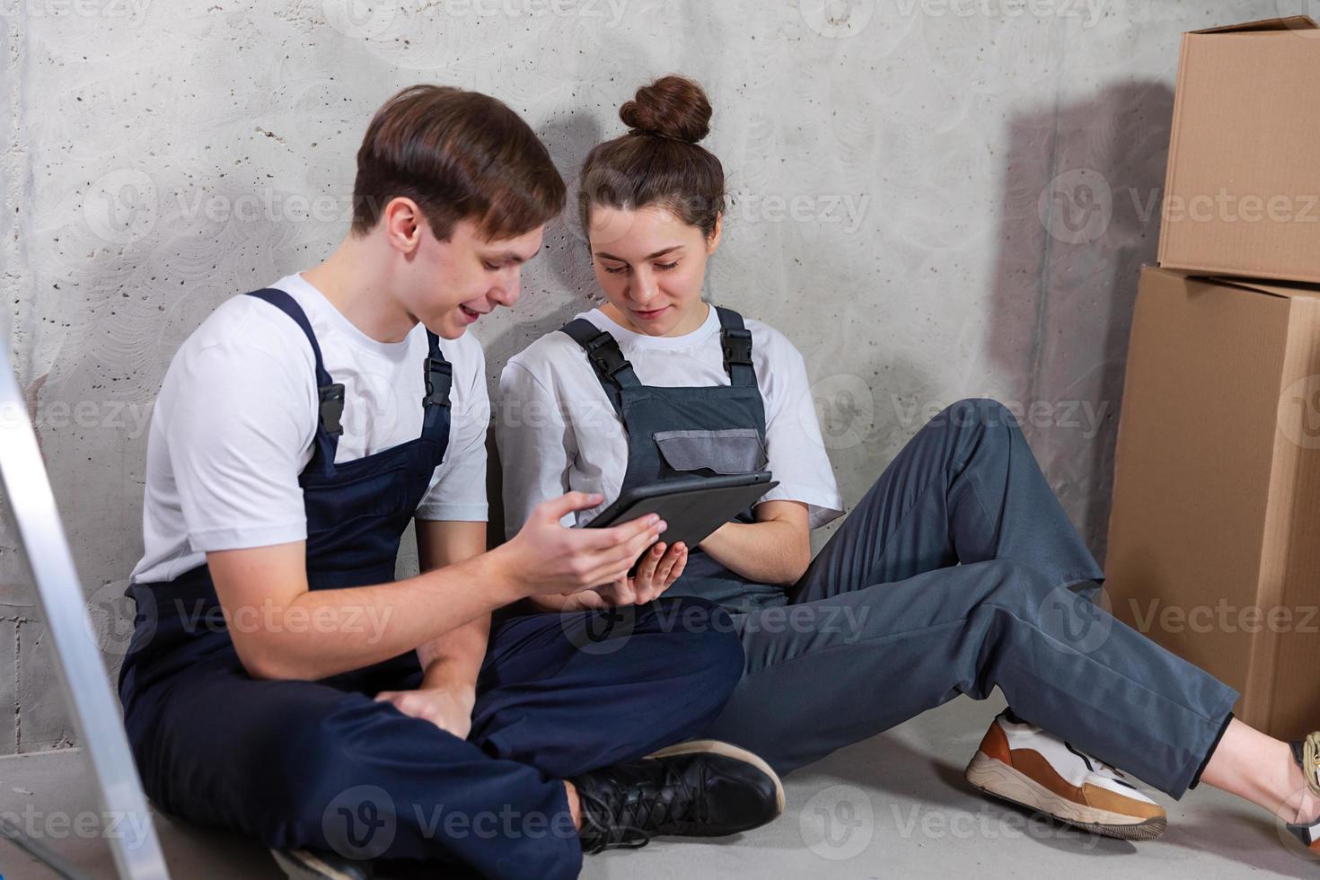 Couple in new home during repair works discussing about home design project looking repair plan on tablet. Happy family choosing new decorations and design. Home renovation DIY renew makeover concept. photo