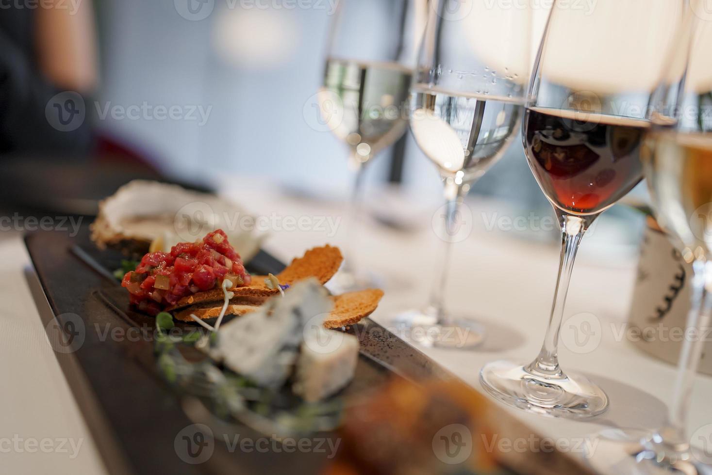 Appetizers and wineglasses on dining table at luxury restaurant photo