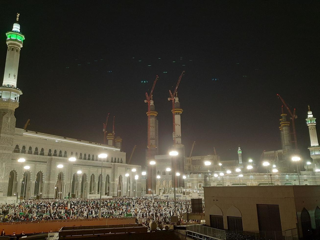Mecca, Saudi Arabia, April 2023 - A beautiful view of pilgrims, tall buildings and lights at night on the outer road in Masjid al-Haram, Mecca. photo