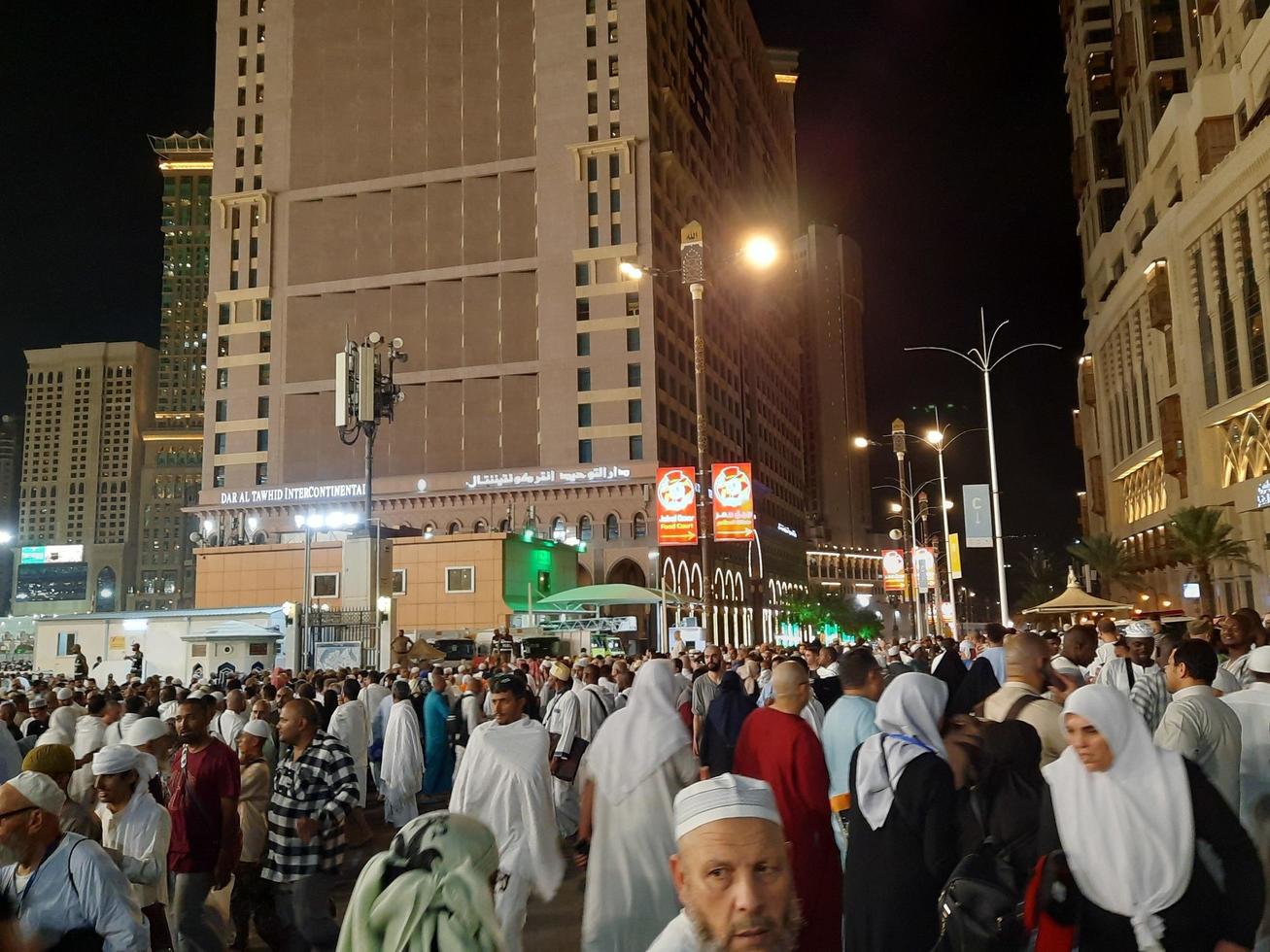 Mecca, Saudi Arabia, April 2023 - A beautiful view of pilgrims, tall buildings and lights at night on the outer road in Masjid al-Haram, Mecca. photo