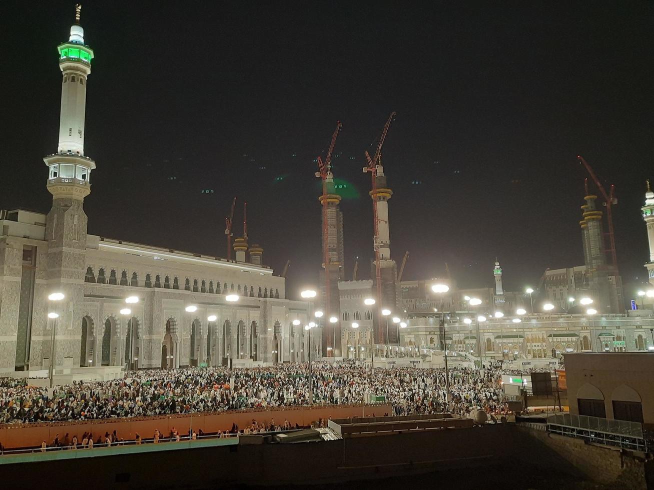 Mecca, Saudi Arabia, April 2023 - A beautiful view of pilgrims, tall buildings and lights at night on the outer road in Masjid al-Haram, Mecca. photo