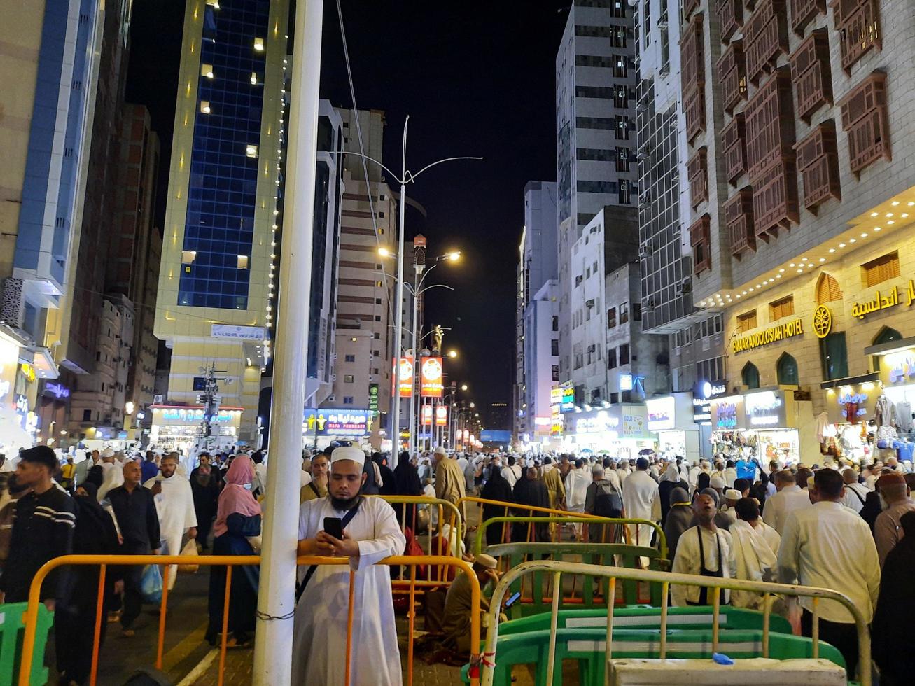 Mecca, Saudi Arabia, April 2023 - A beautiful view of pilgrims, tall buildings and lights at night on the outer road in Masjid al-Haram, Mecca. photo