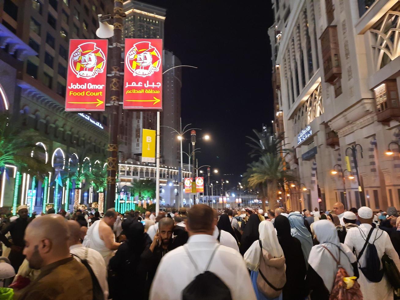 Mecca, Saudi Arabia, April 2023 - A beautiful view of pilgrims, tall buildings and lights at night on the outer road in Masjid al-Haram, Mecca. photo
