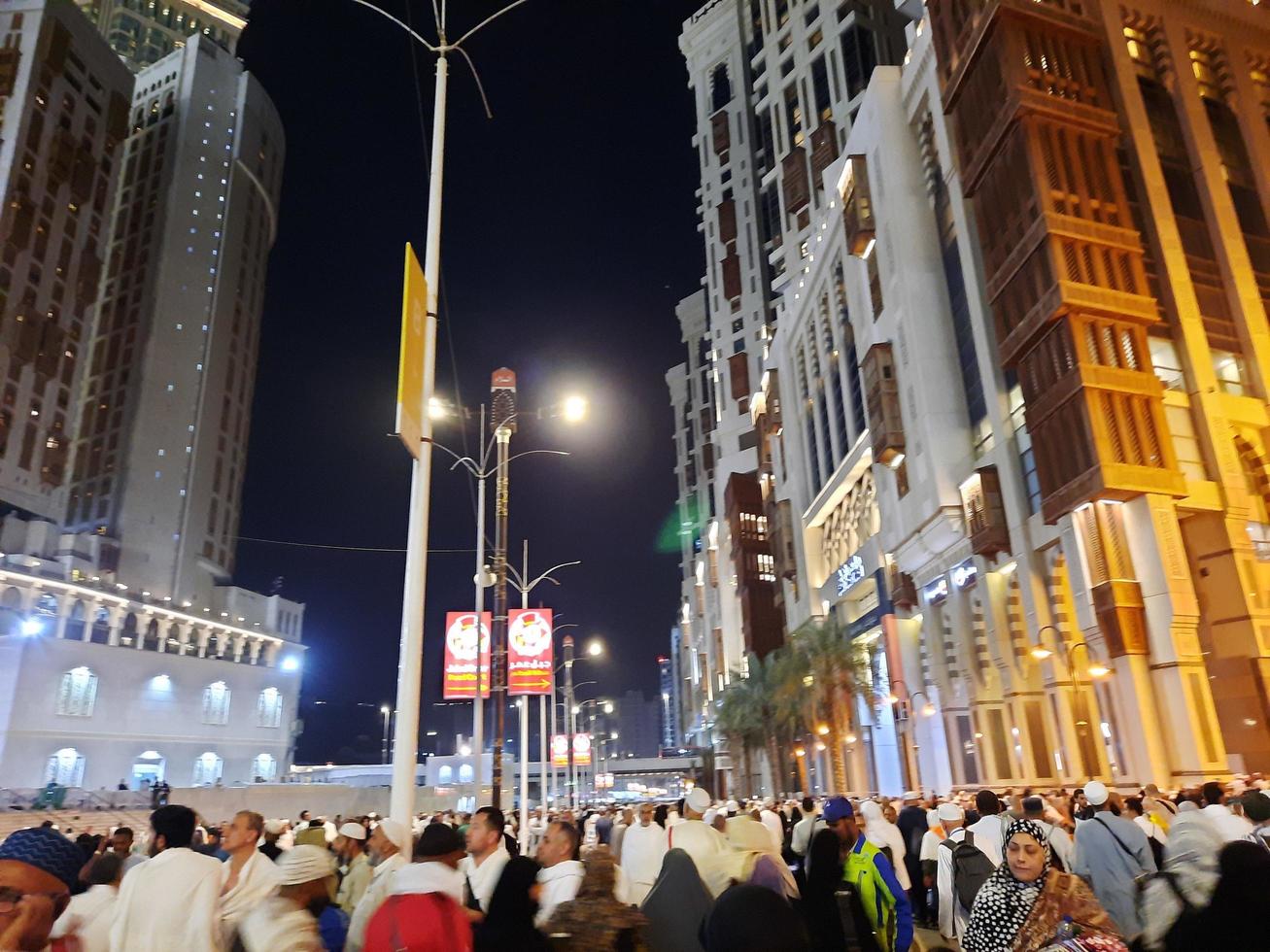 Mecca, Saudi Arabia, April 2023 - A beautiful view of pilgrims, tall buildings and lights at night on the outer road in Masjid al-Haram, Mecca. photo