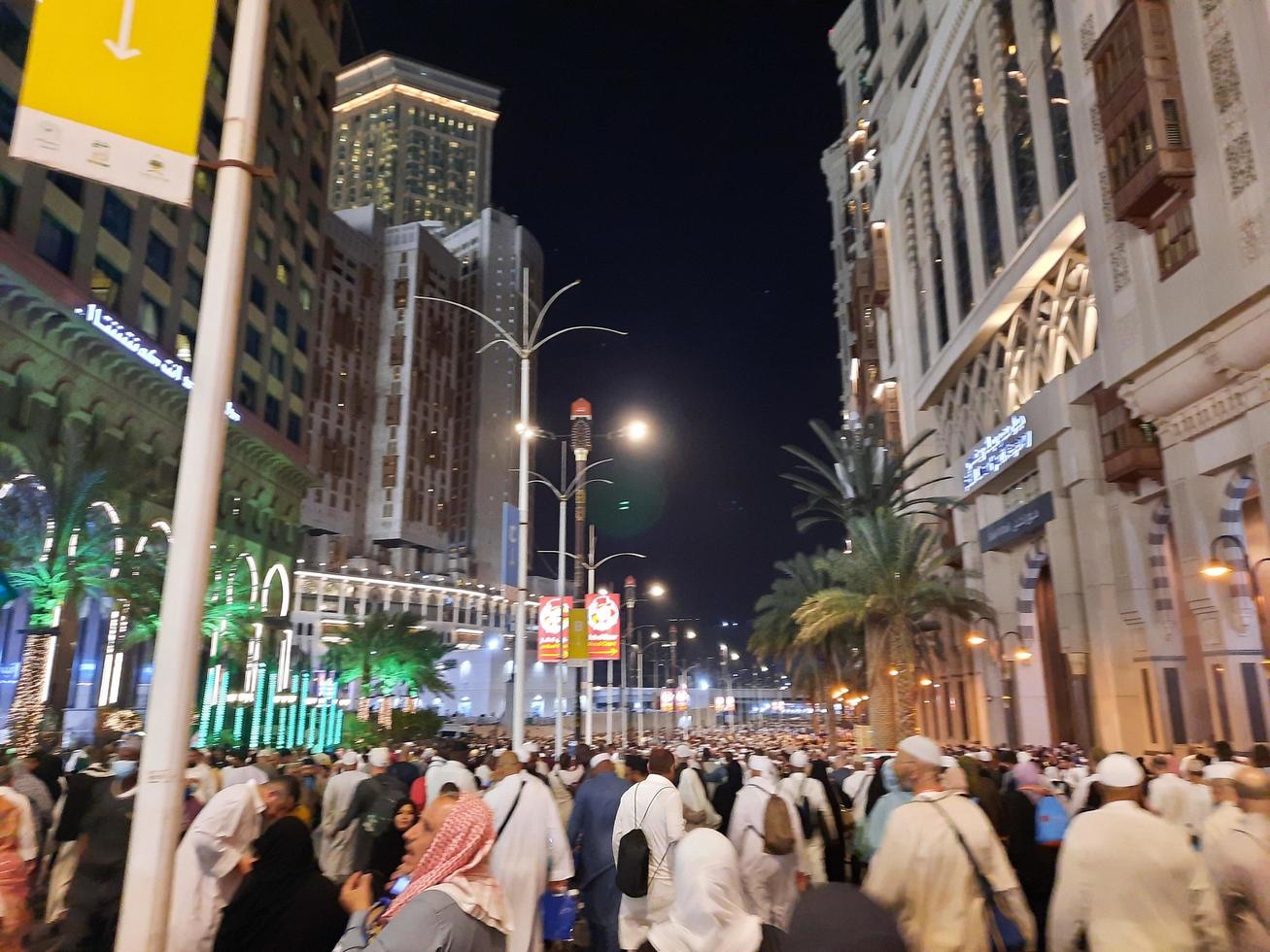 Mecca, Saudi Arabia, April 2023 - A beautiful view of pilgrims, tall buildings and lights at night on the outer road in Masjid al-Haram, Mecca. photo