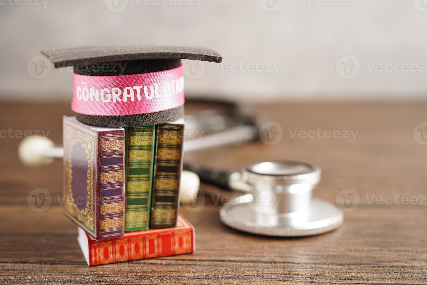 Graduation hat on book and stethoscope with copy space, doctor learning medicine university education concept. photo