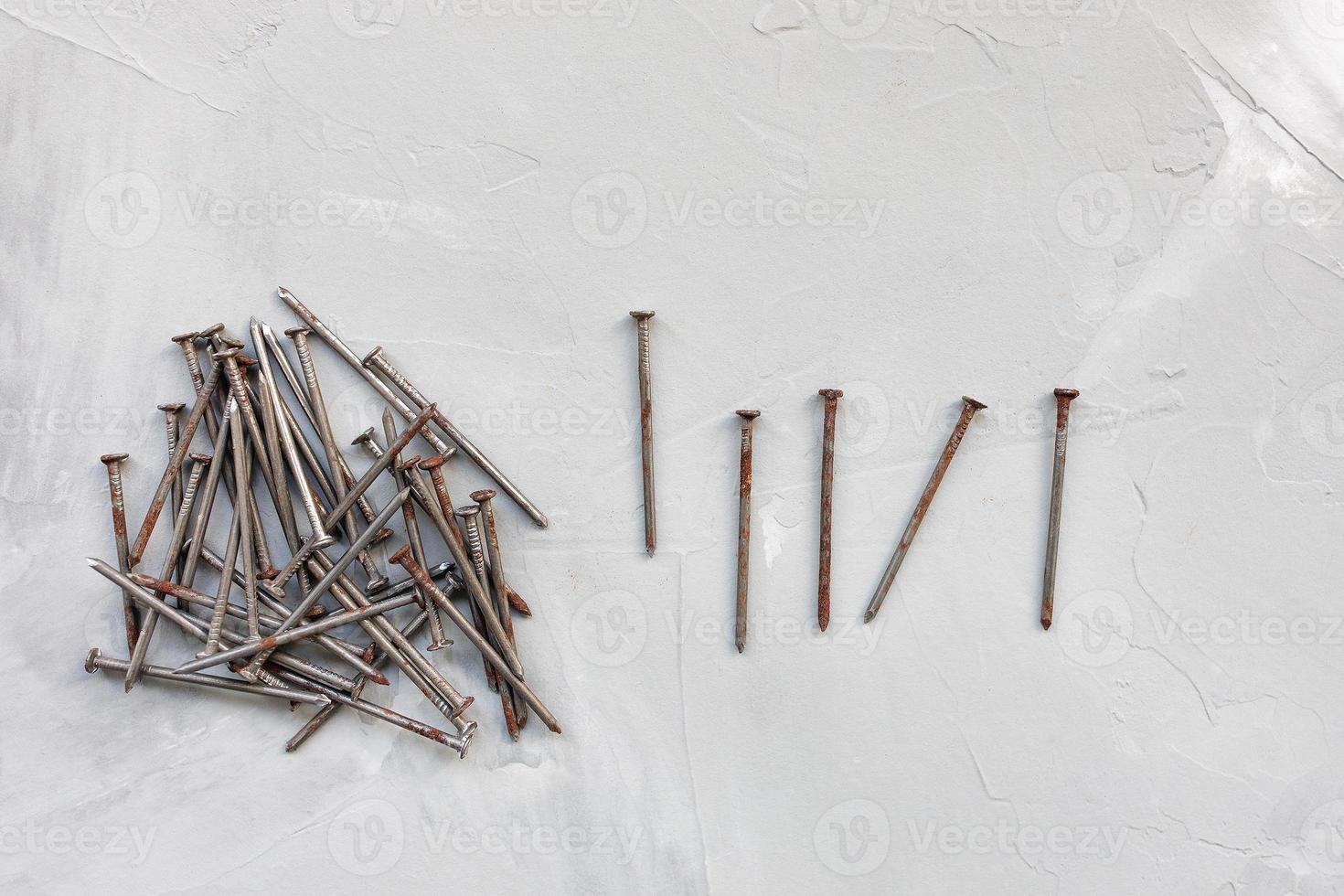 Old rusty nails on gray background photo