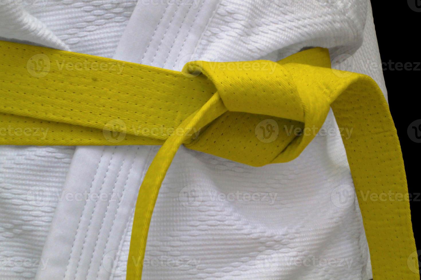 Yellow obi sash tied around a gi photo