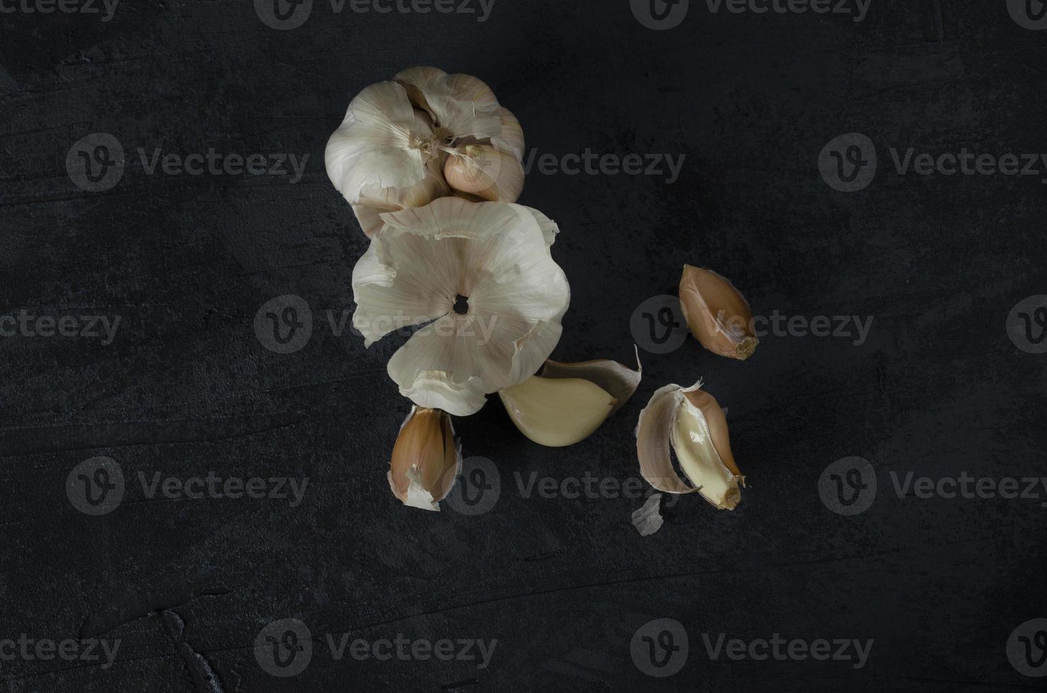 The garlic, garlic cloves and skin on the dark background. photo