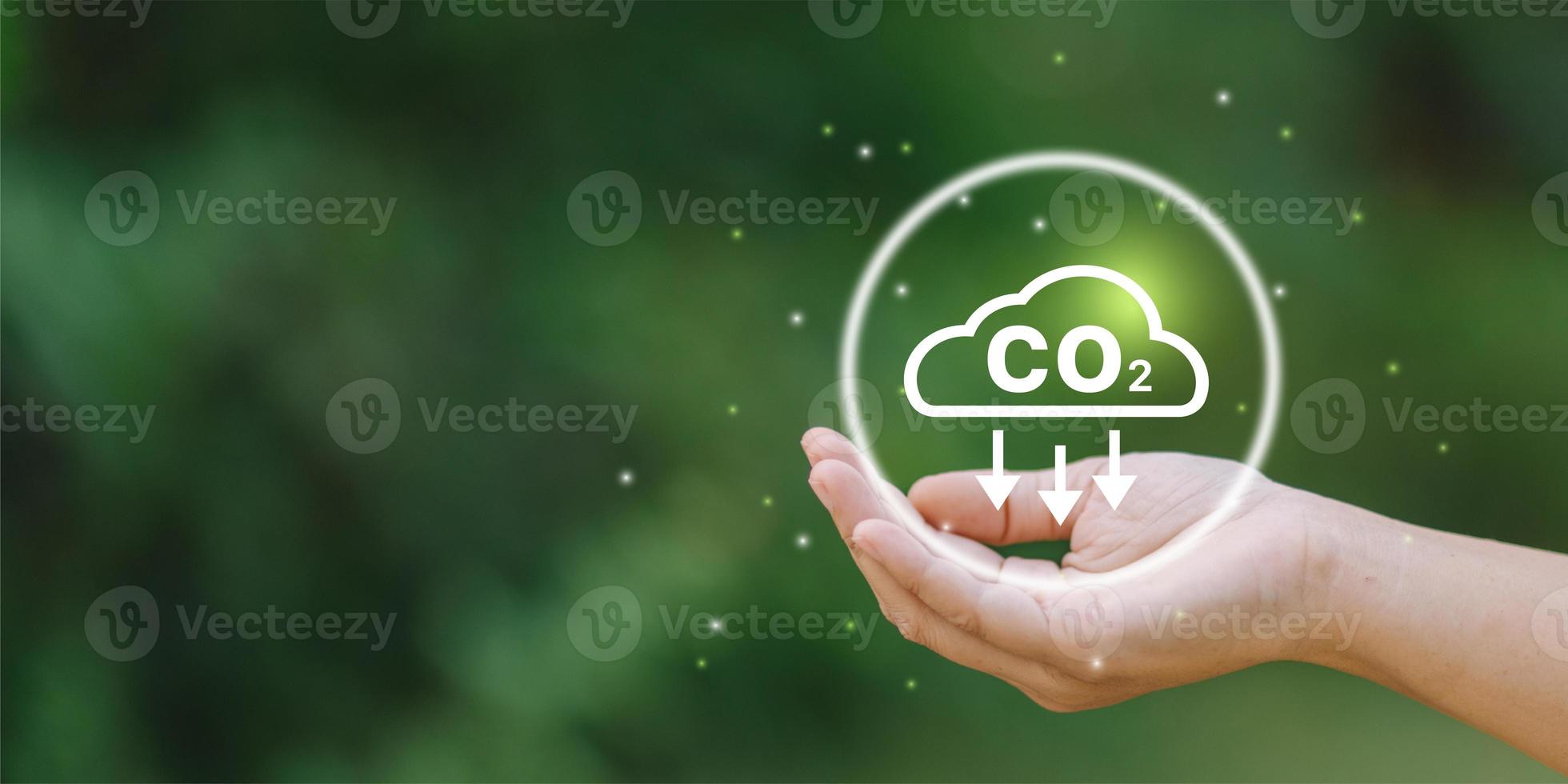 Businessman holding Co2 icon on virtual screen Reduce CO2 emissions to limit global warming. Lower CO2 levels with sustainable photo