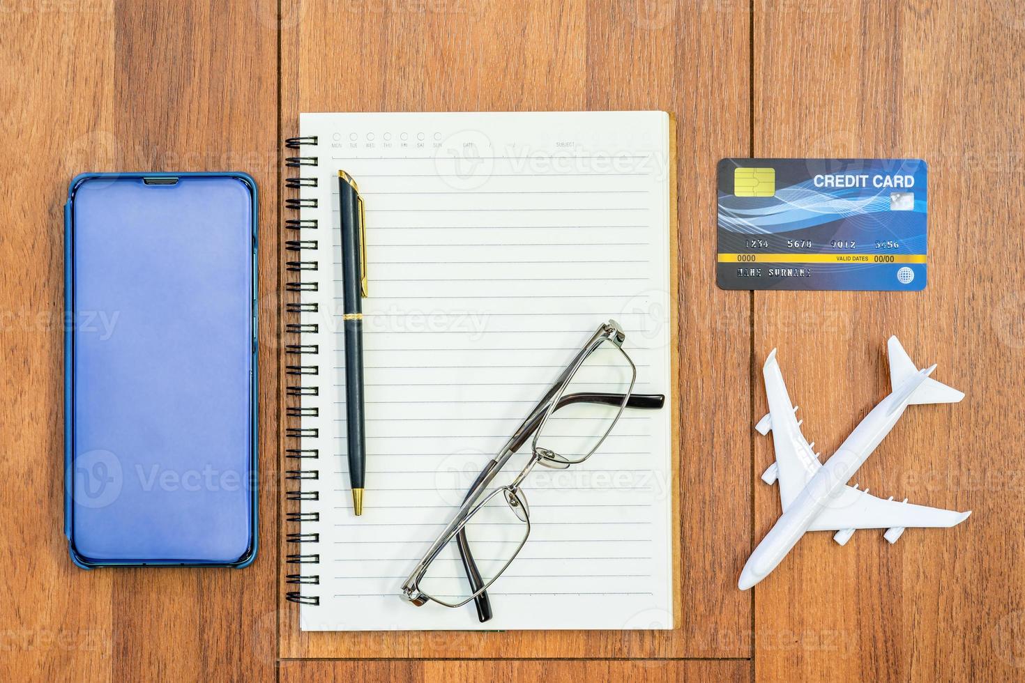 Top view image of open notebook with blank page and cellphone on table photo