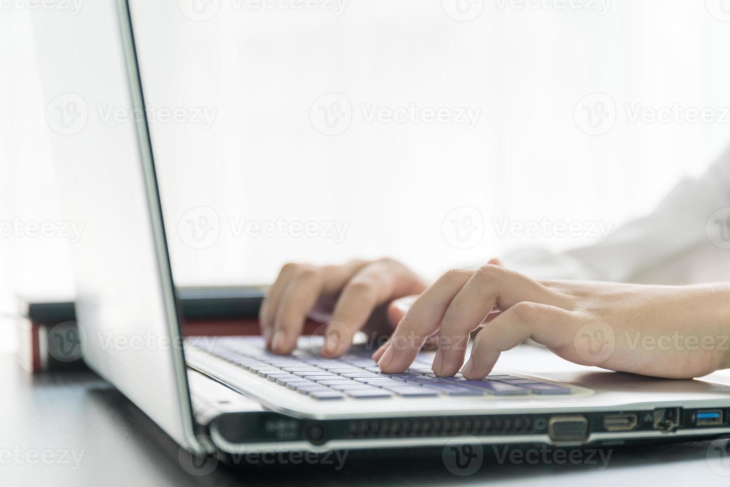 Woman hands typing on laptop keyboard photo