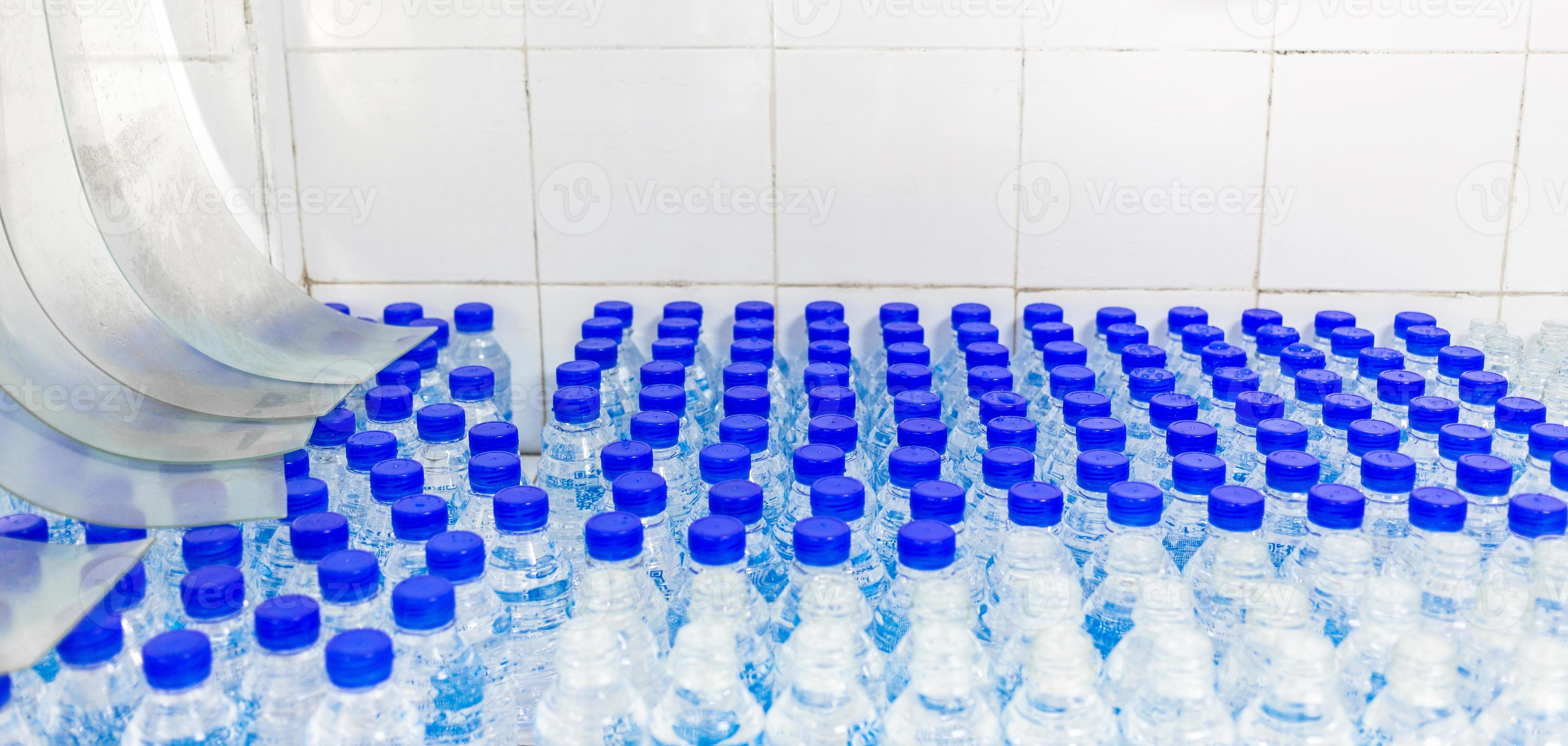 Lots of water bottles. Bottles with blue caps. Bottling plantWater